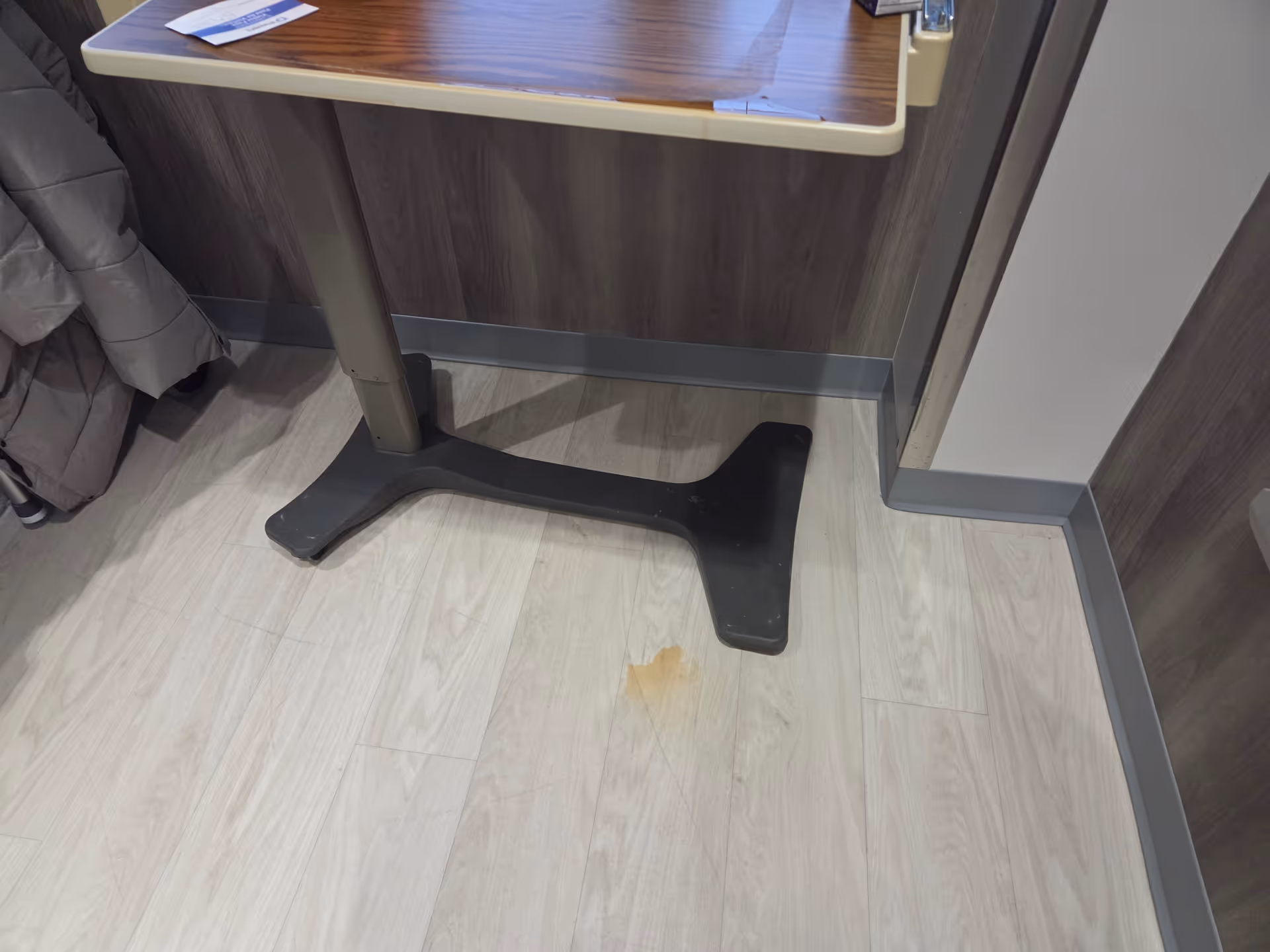 A small table with a black pedestal base on a light wood floor.
