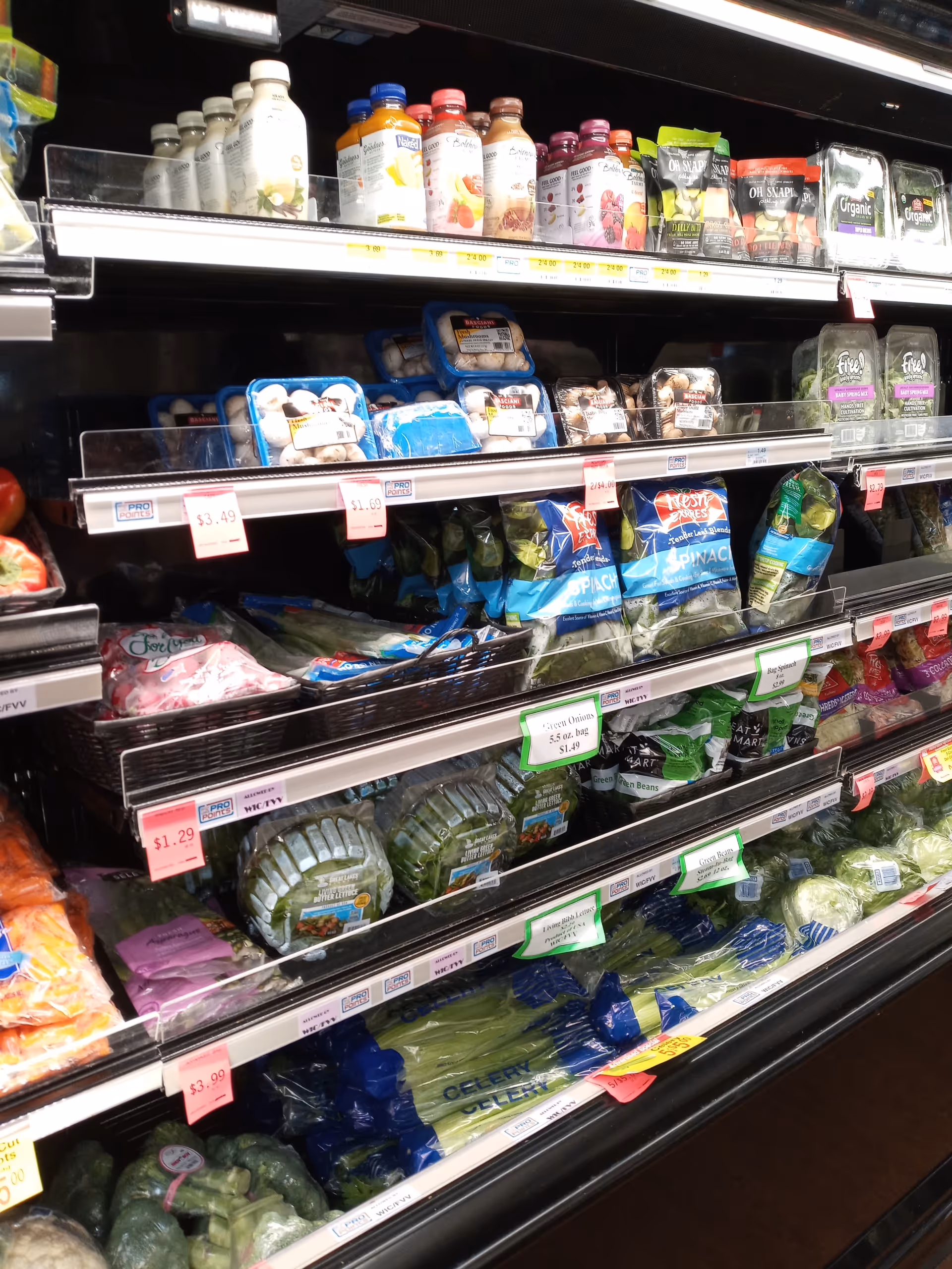 A grocery aisle at Discount Drug Mart with bottled drinks, produce, and packaged goods.