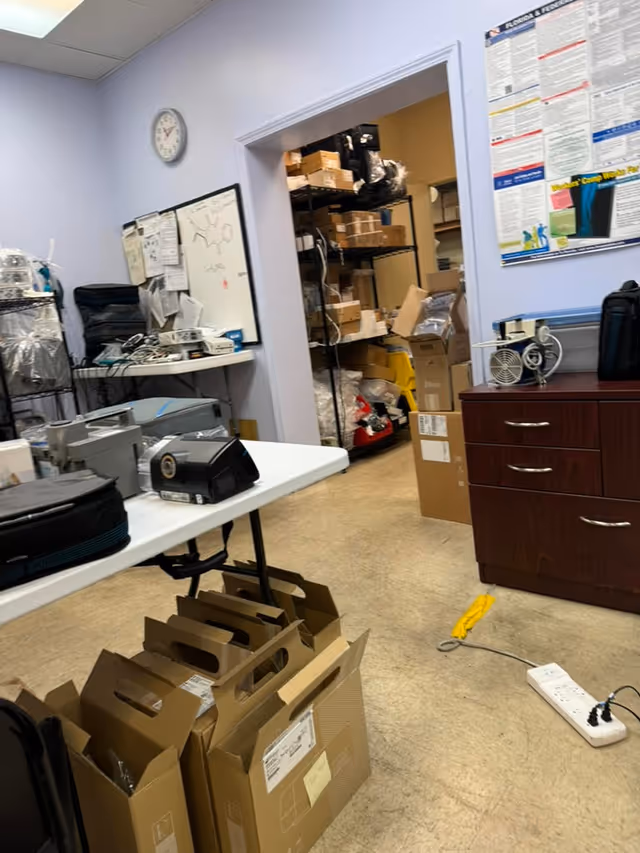 A cluttered storage room in a senior care facility with boxes, shelves, and equipment.