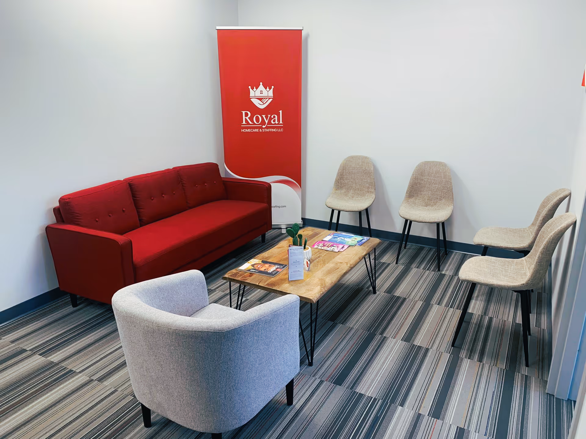 Lobby seating area with red sofa, beige chairs, and a Royal banner.