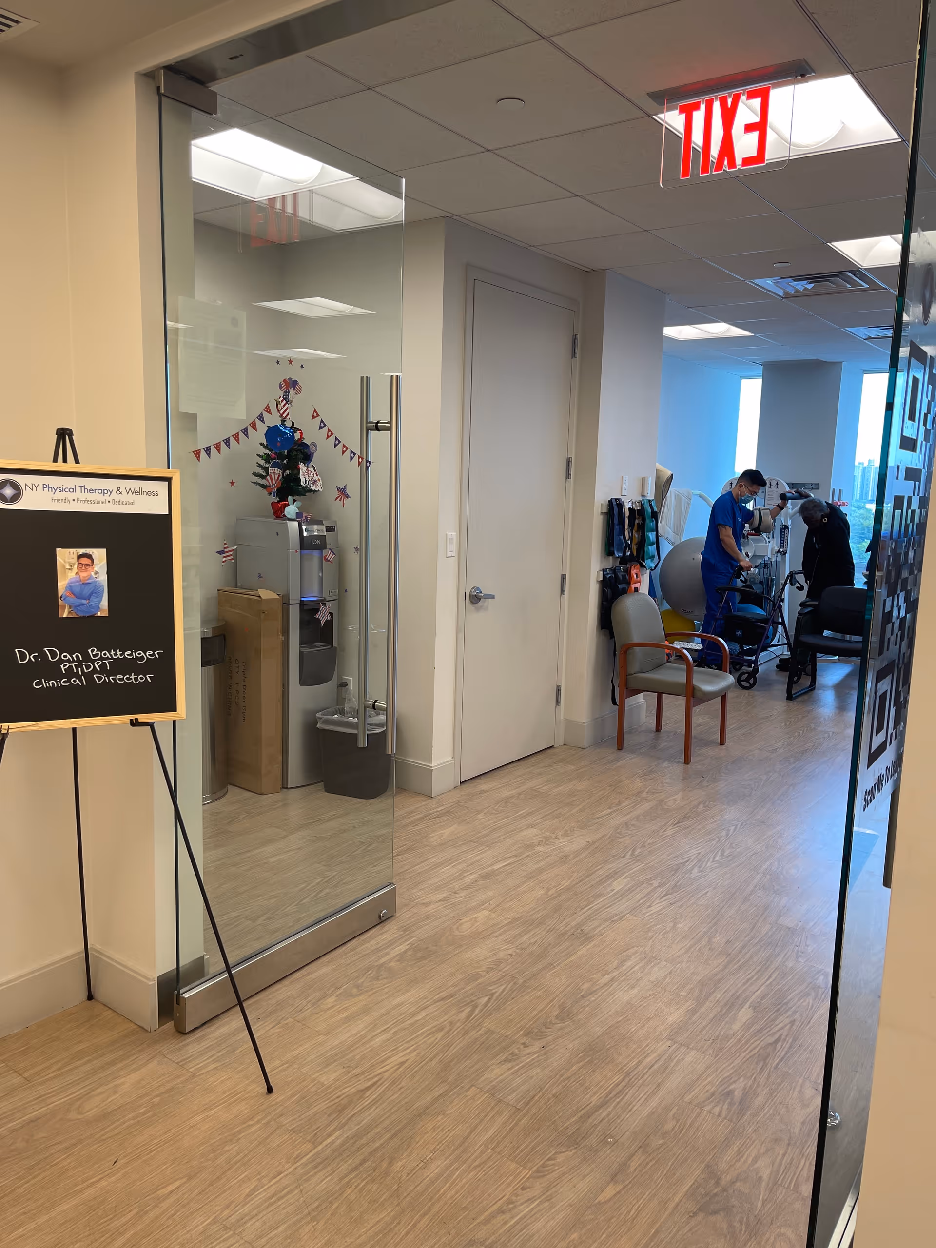 Interior corridor of JAG Physical Therapy in a senior living facility, with glass doors and staff.