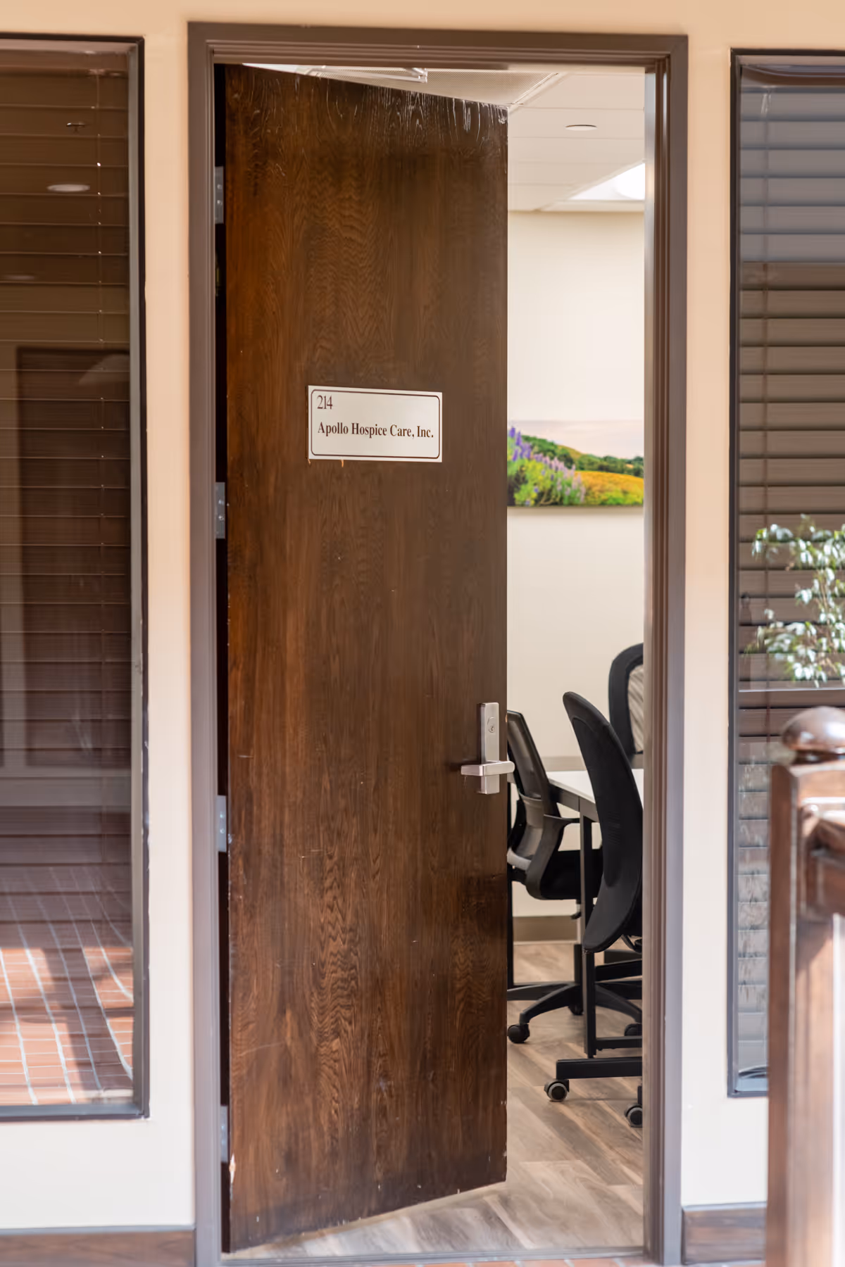Wooden door labeled Apollo Hospice Care, Inc., opens to a conference room.