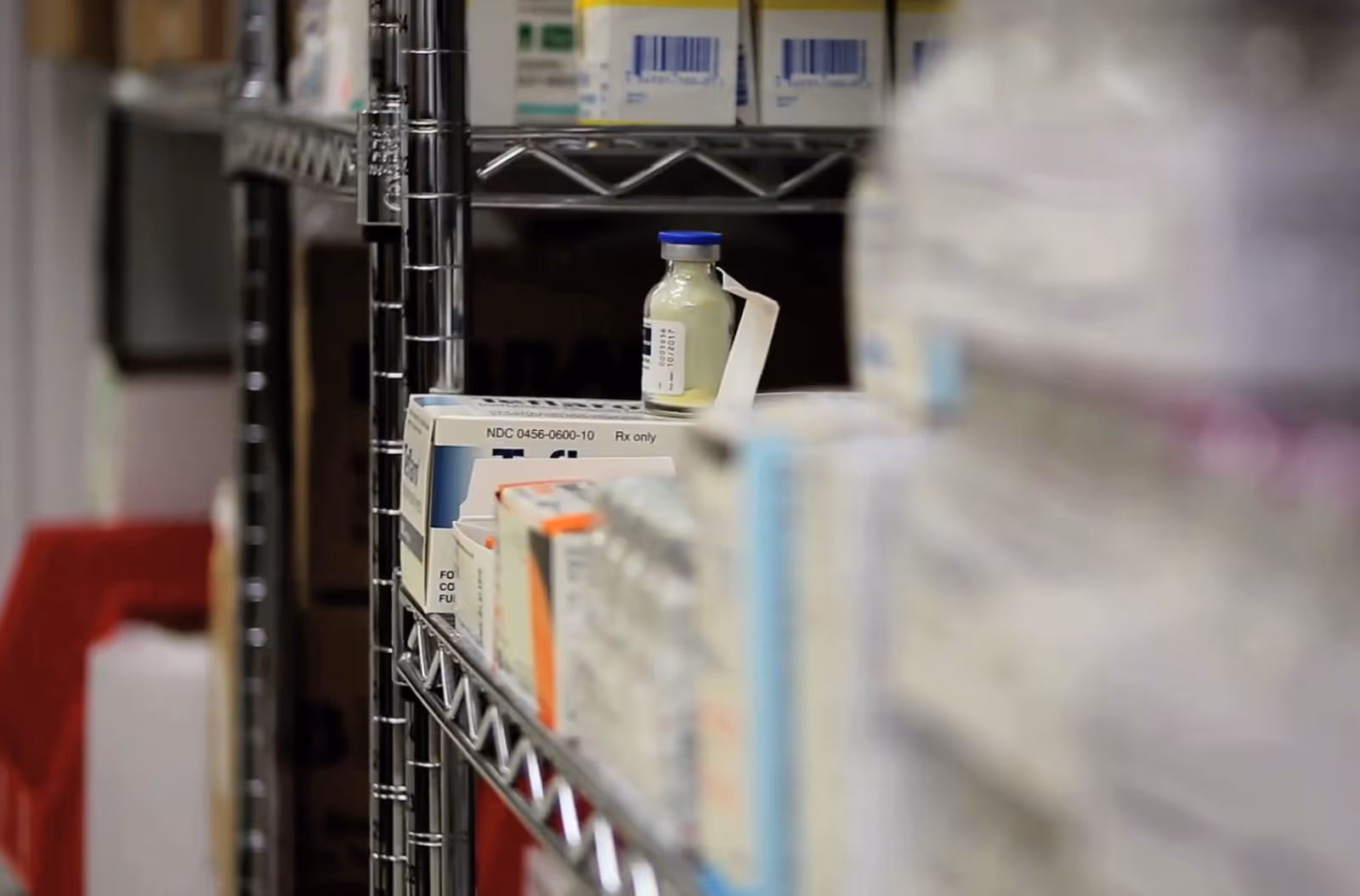 Metal shelving with medical supplies in a storage area.