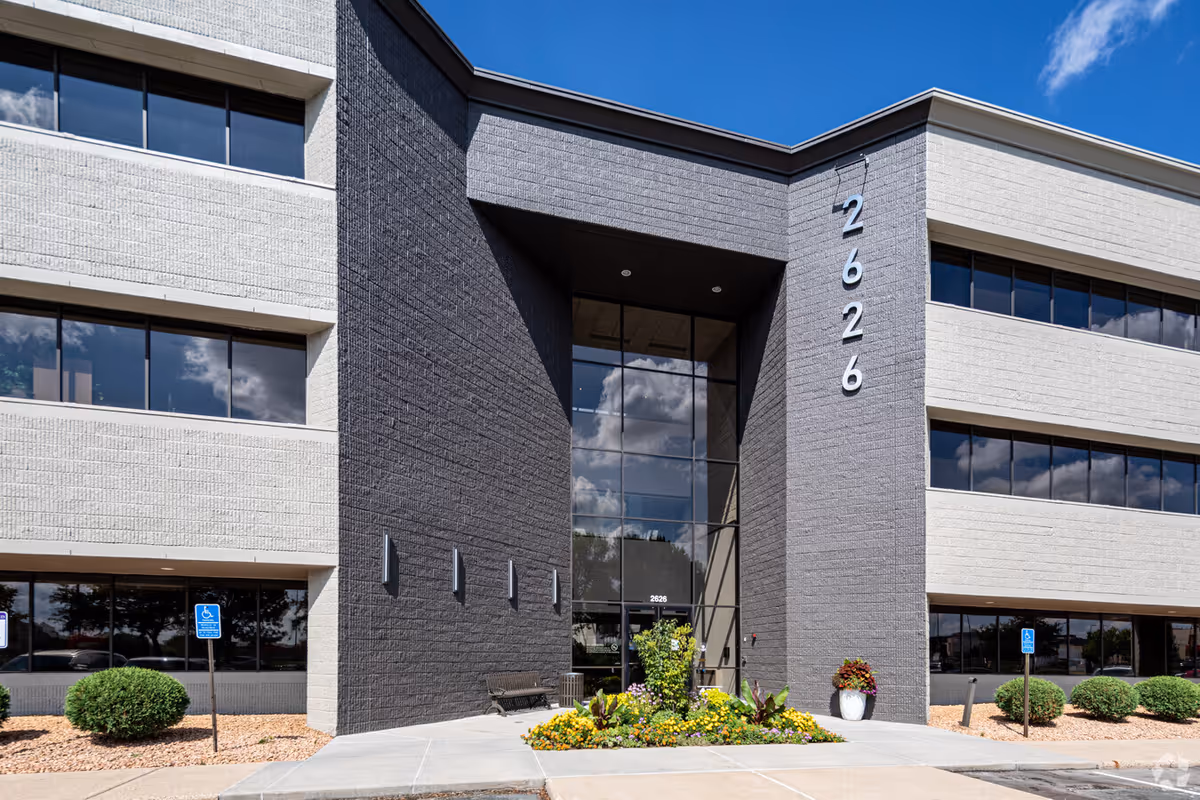 Modern senior living facility exterior with glass entrance and landscaped front