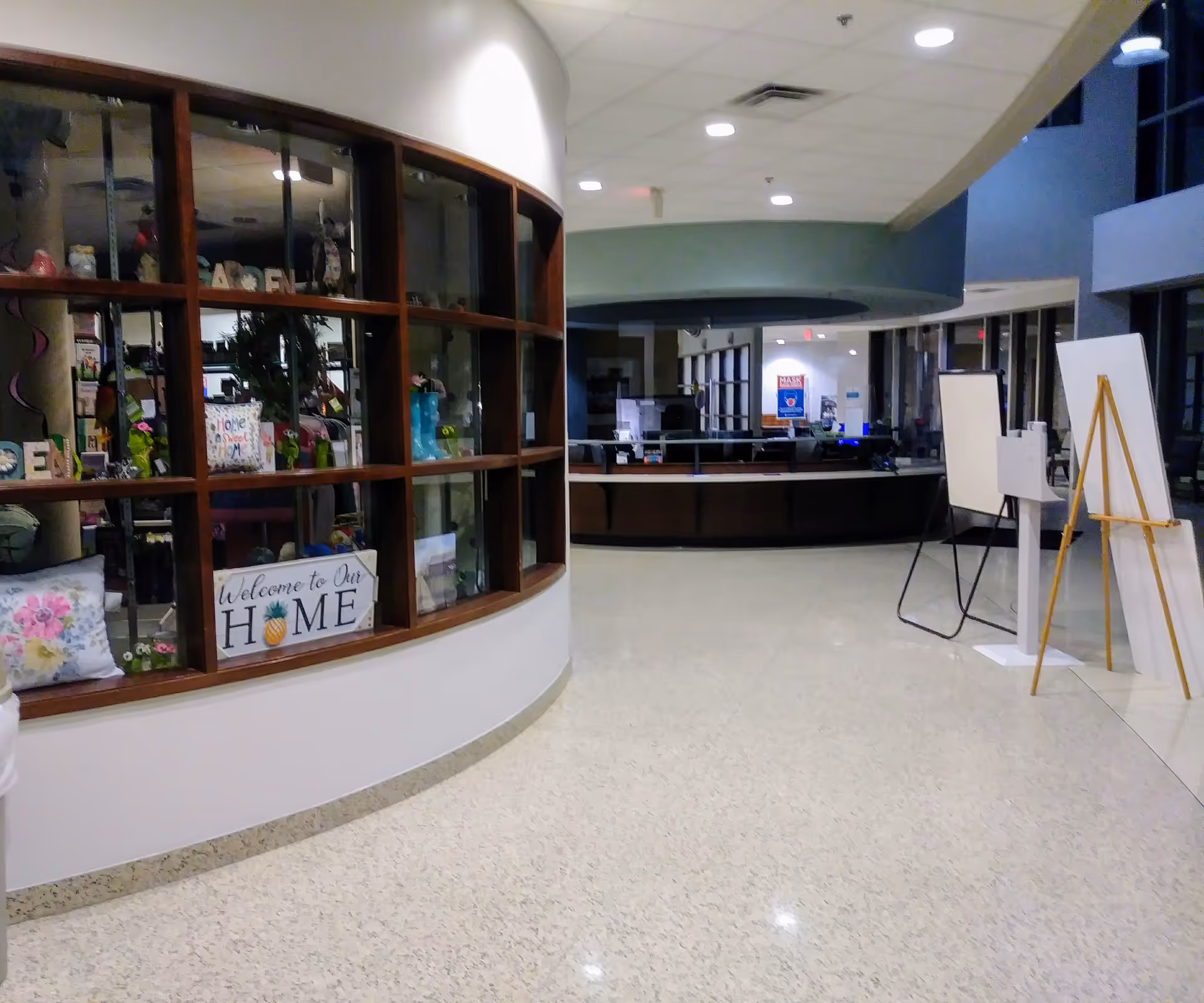 Curved wooden display window and reception desk in a hospital lobby.