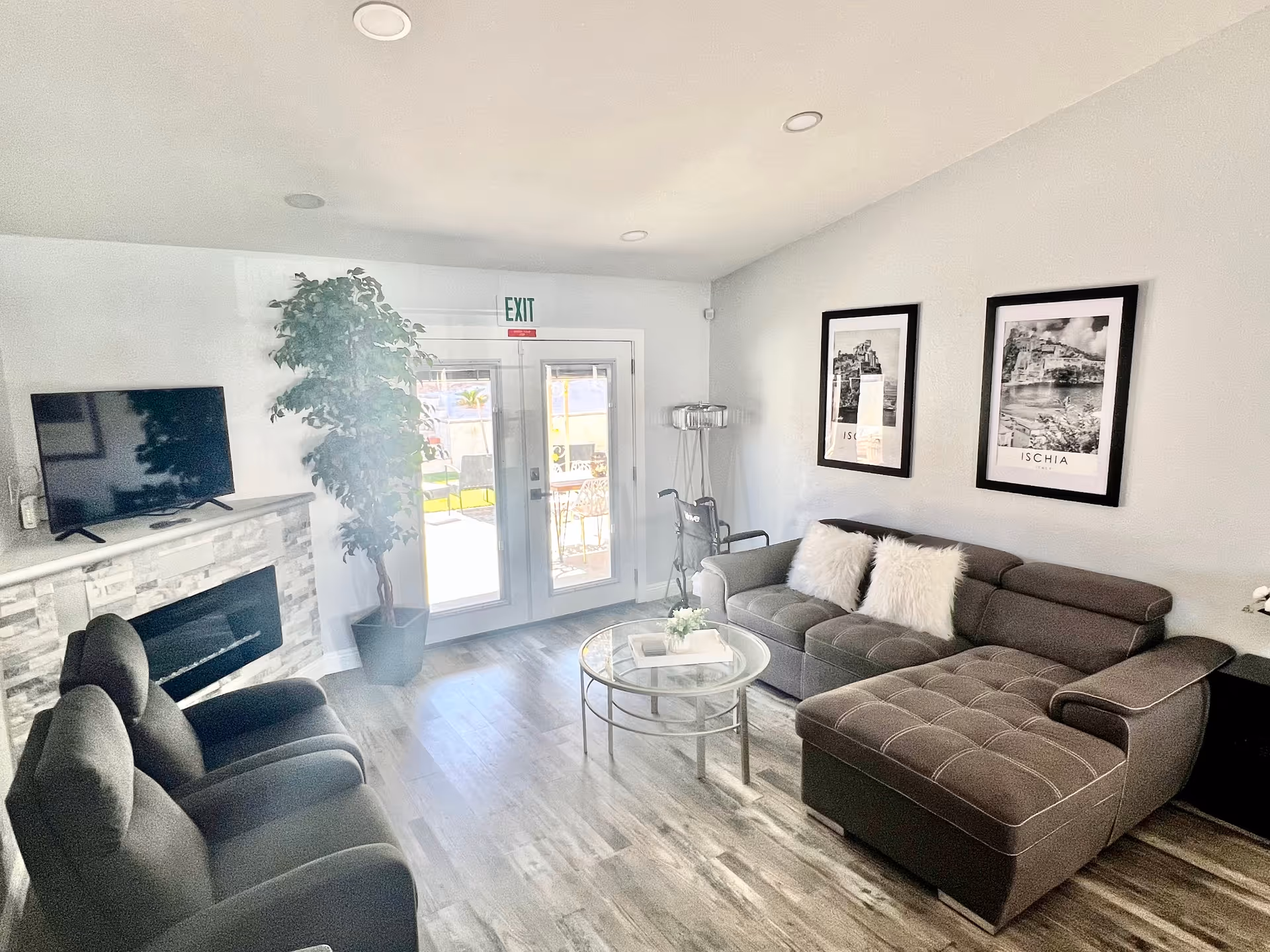 Cozy modern living room with gray sectional, fireplace, TV, and framed wall art.
