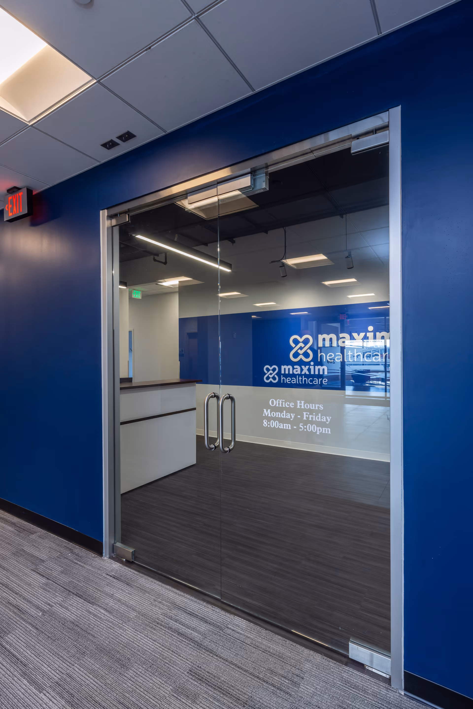 Glass entrance to Maxim Healthcare Canton, OH Regional Office with blue walls and glass doors.