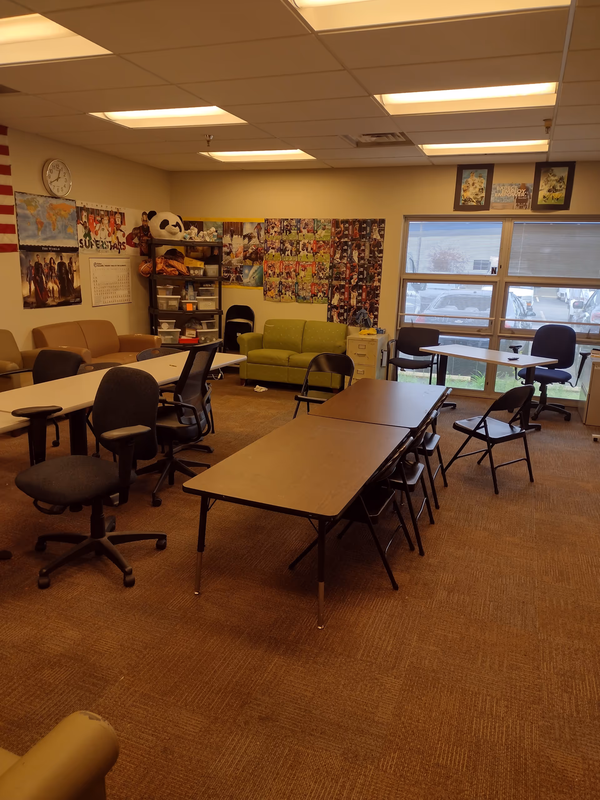 Interior common area in a senior facility with tables, chairs, and a green sofa.