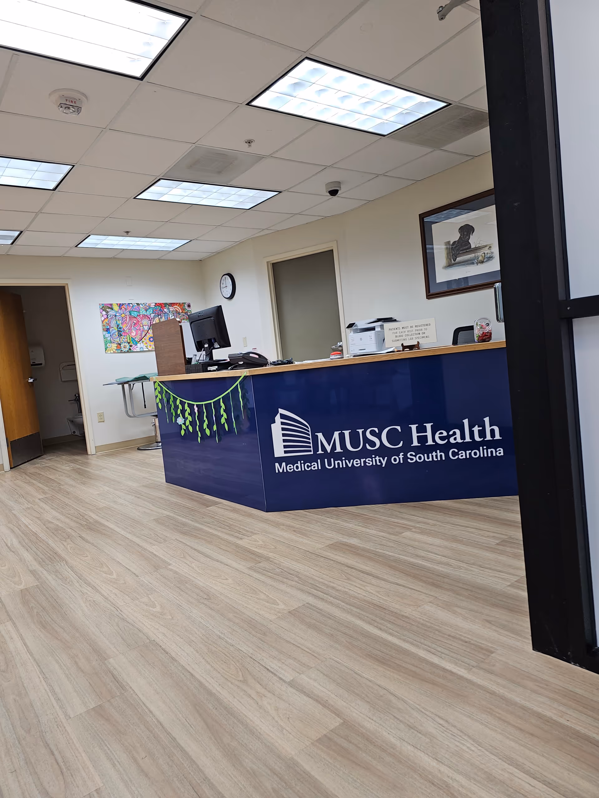 Reception desk in MUSC Health lobby with computer and paperwork.