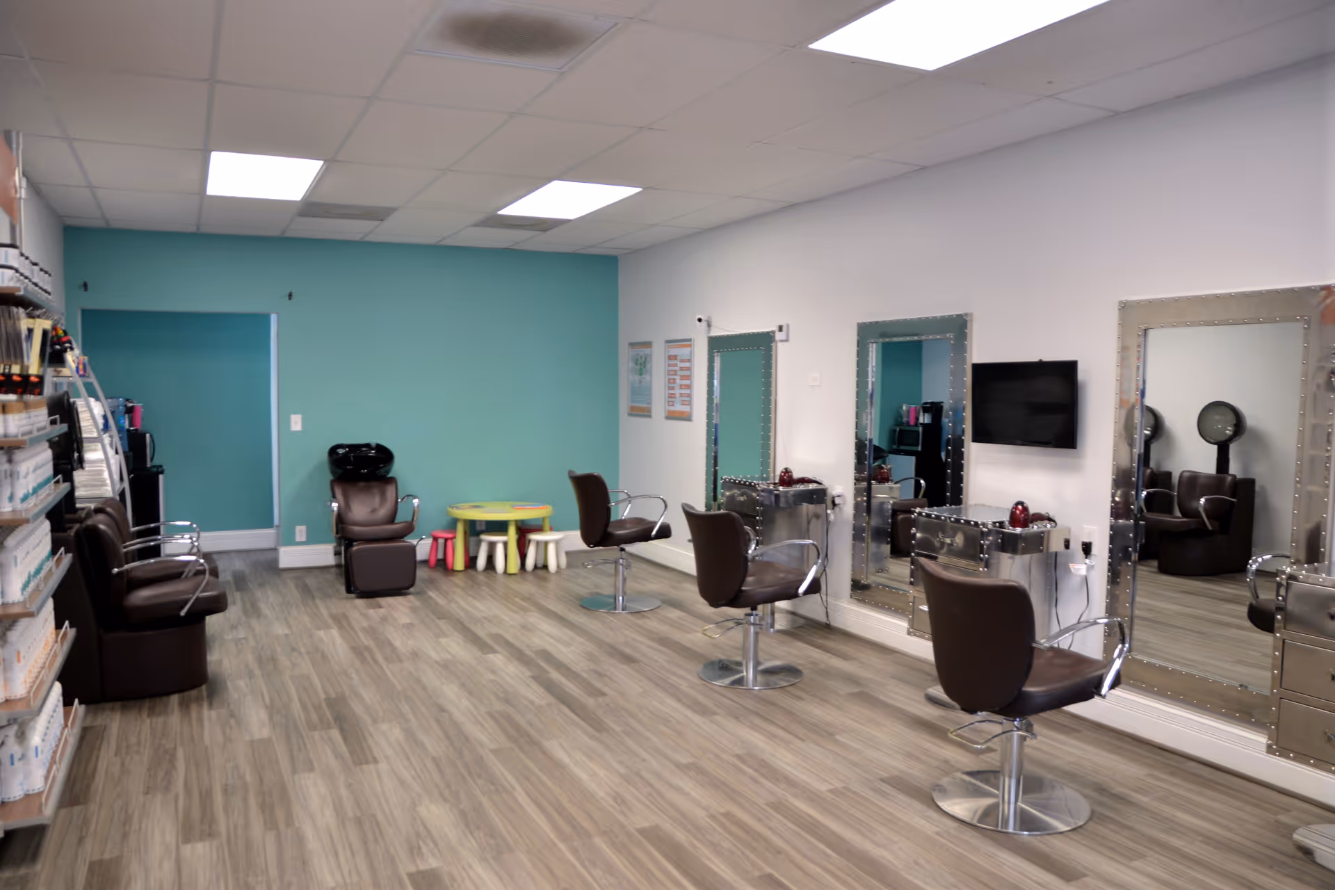 Bright salon interior with multiple styling chairs, mirrors, and equipment.