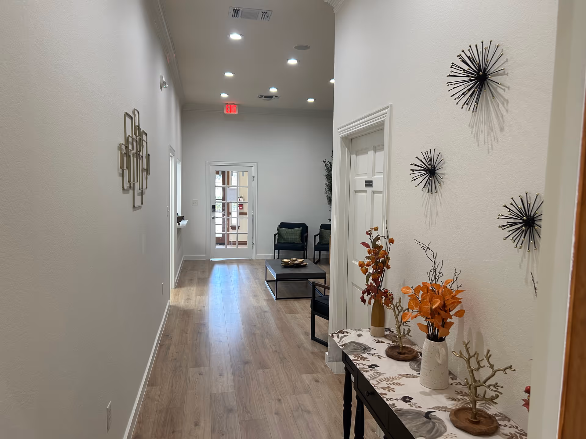 Bright hallway inside a senior living facility with seating area and decorative wall art