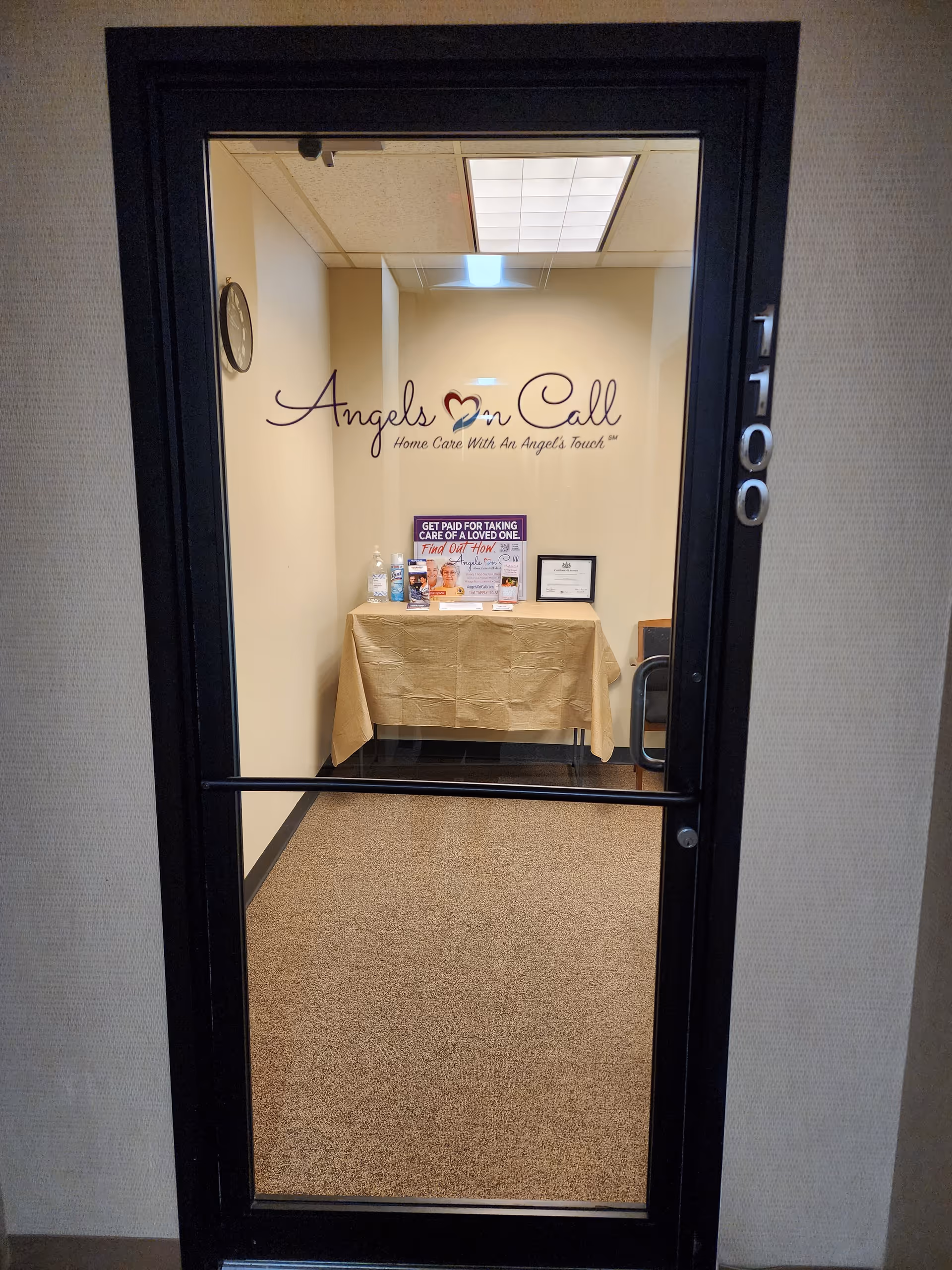 Interior doorway to a reception area with a beige table, brochures, and Angels On Call sign.
