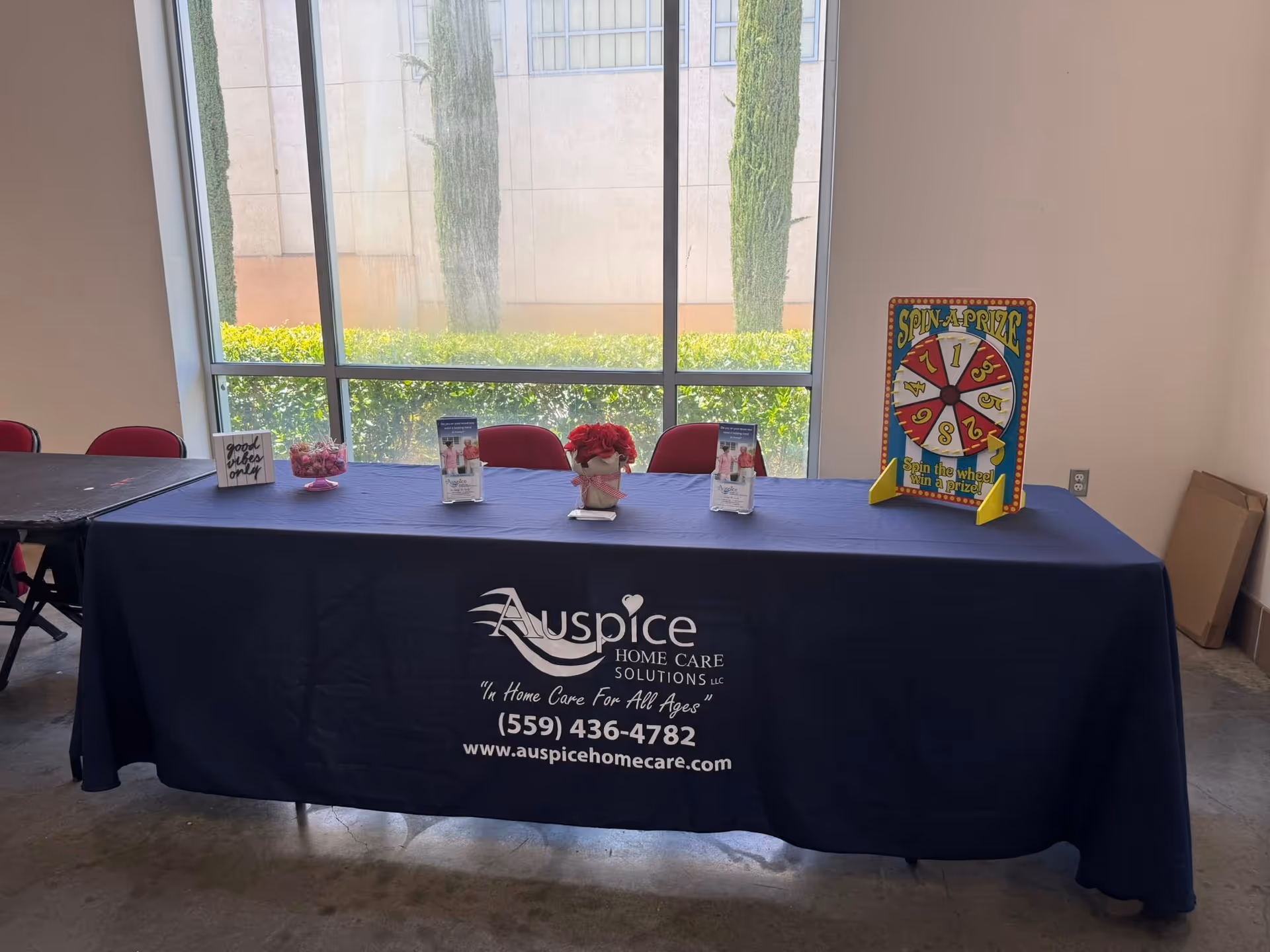 Indoor display table with Auspice Home Care branding and promotional materials.