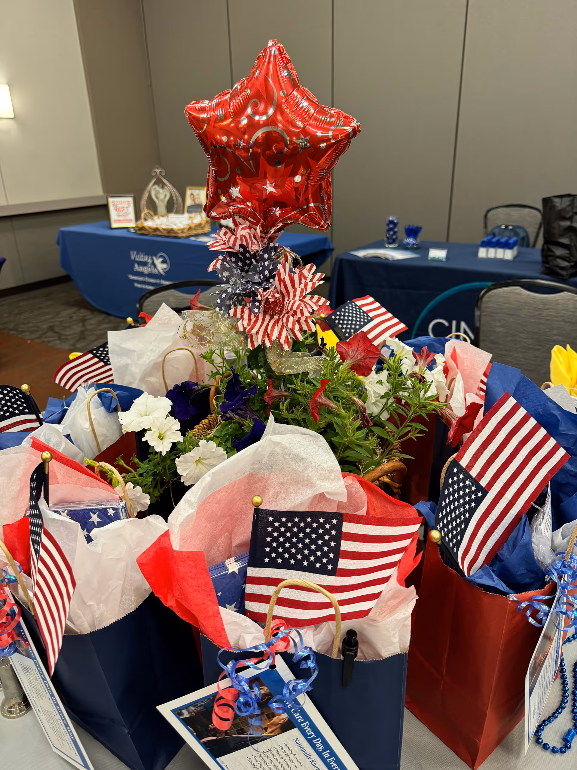 Indoor event table with patriotic gift bags and a red star balloon.
