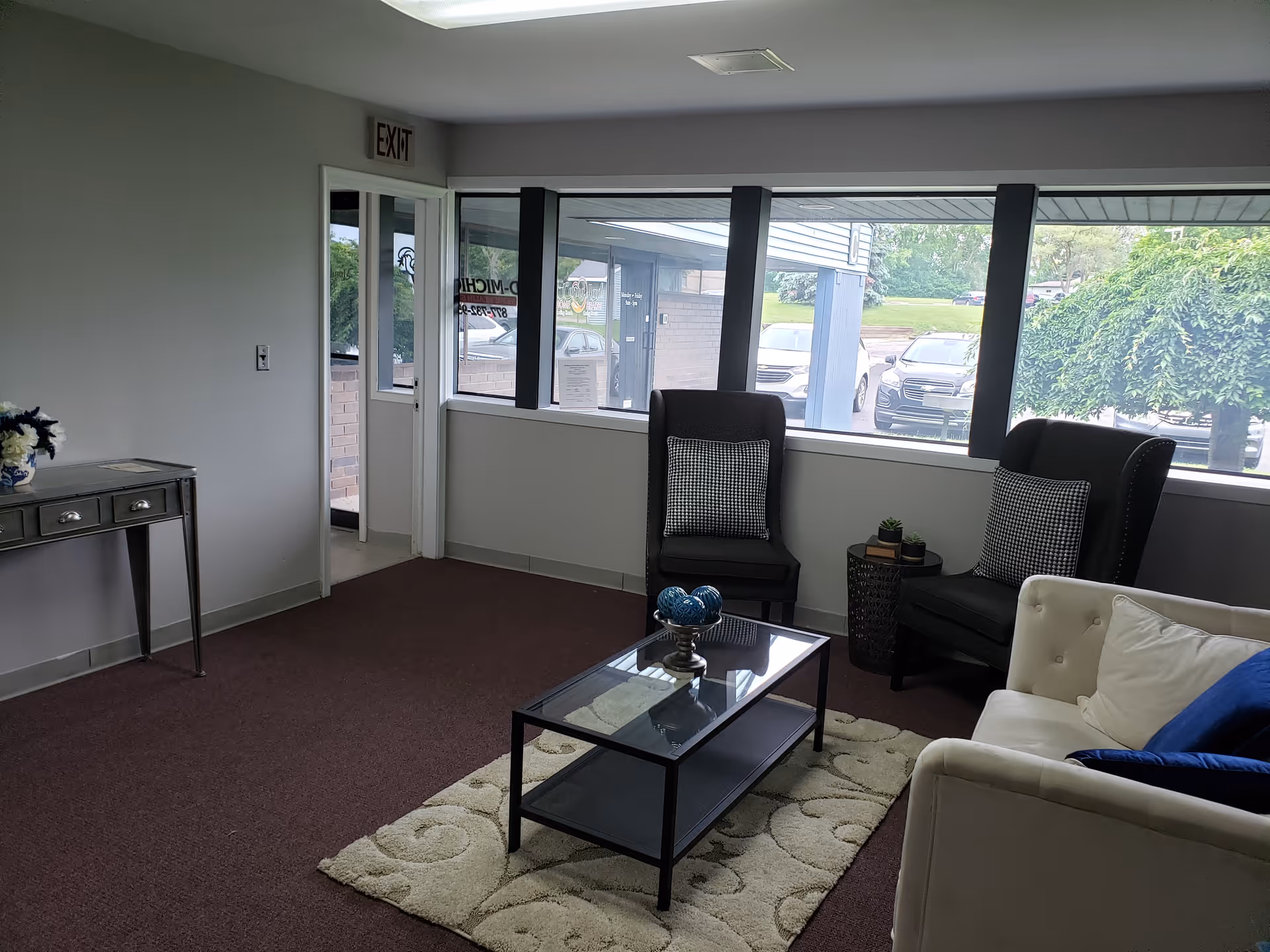 Modern waiting area with seating, coffee table, and large windows.