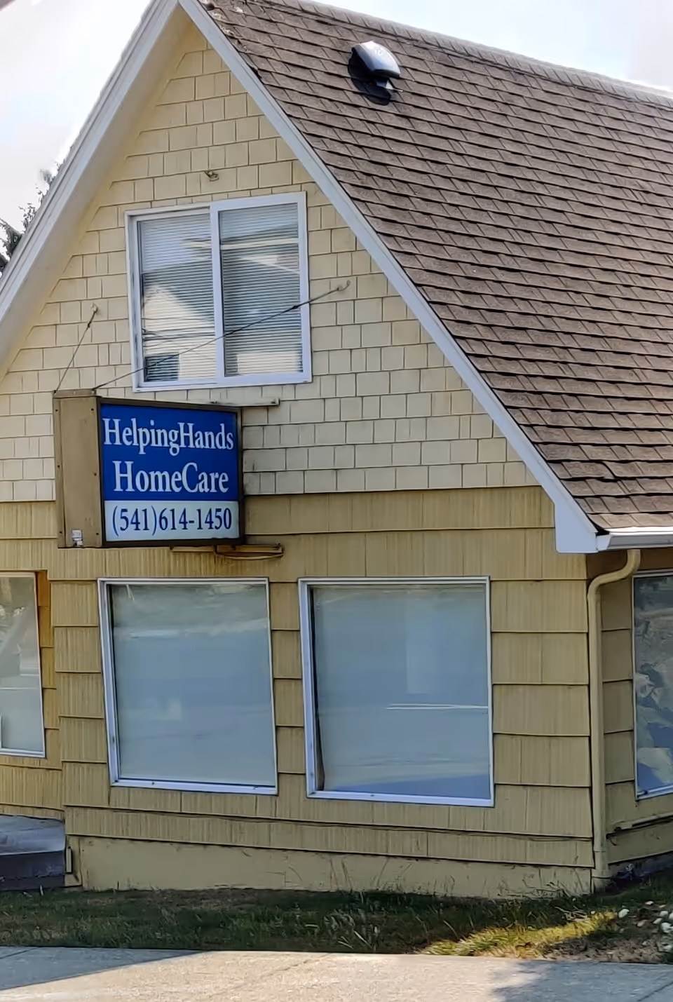 Exterior view of a yellow building with a blue Helping Hands HomeCare sign