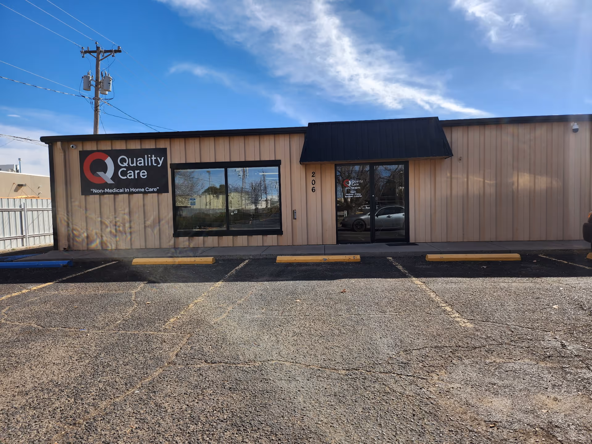 Front view of Quality Care storefront with parking lot and blue sky.