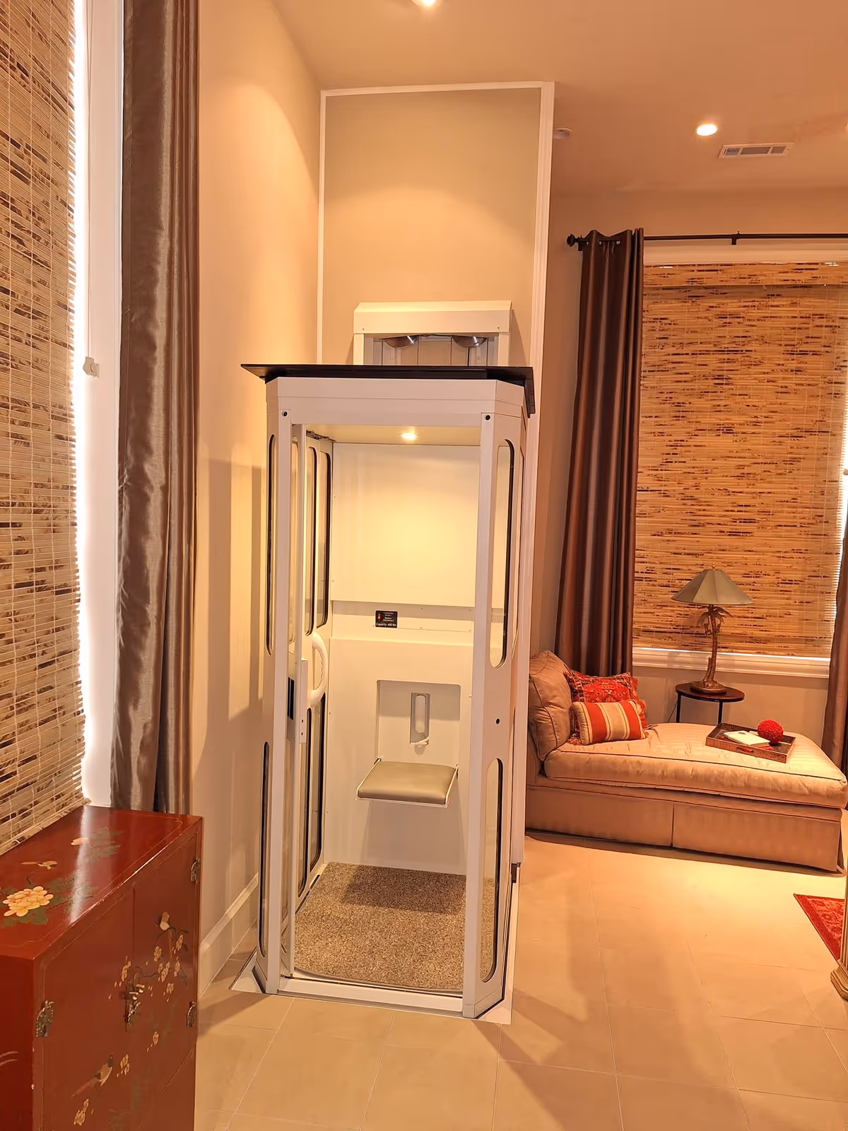A compact residential elevator is installed in a cozy living room.