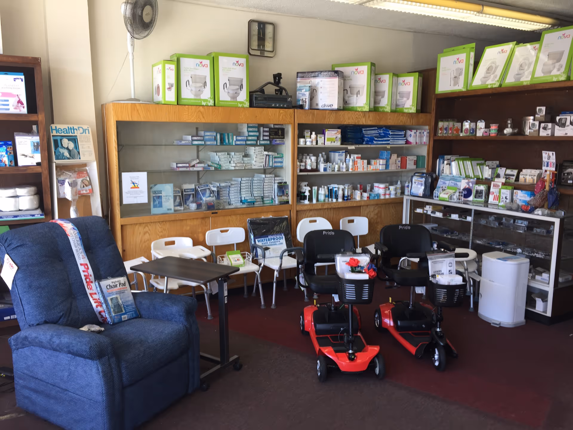 Interior view of a medical supply shop with chairs, mobility scooters, and stocked shelves.