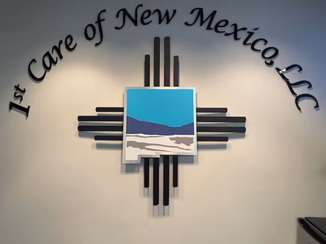 Interior wall featuring a cross-shaped black sculpture and framed landscape artwork.