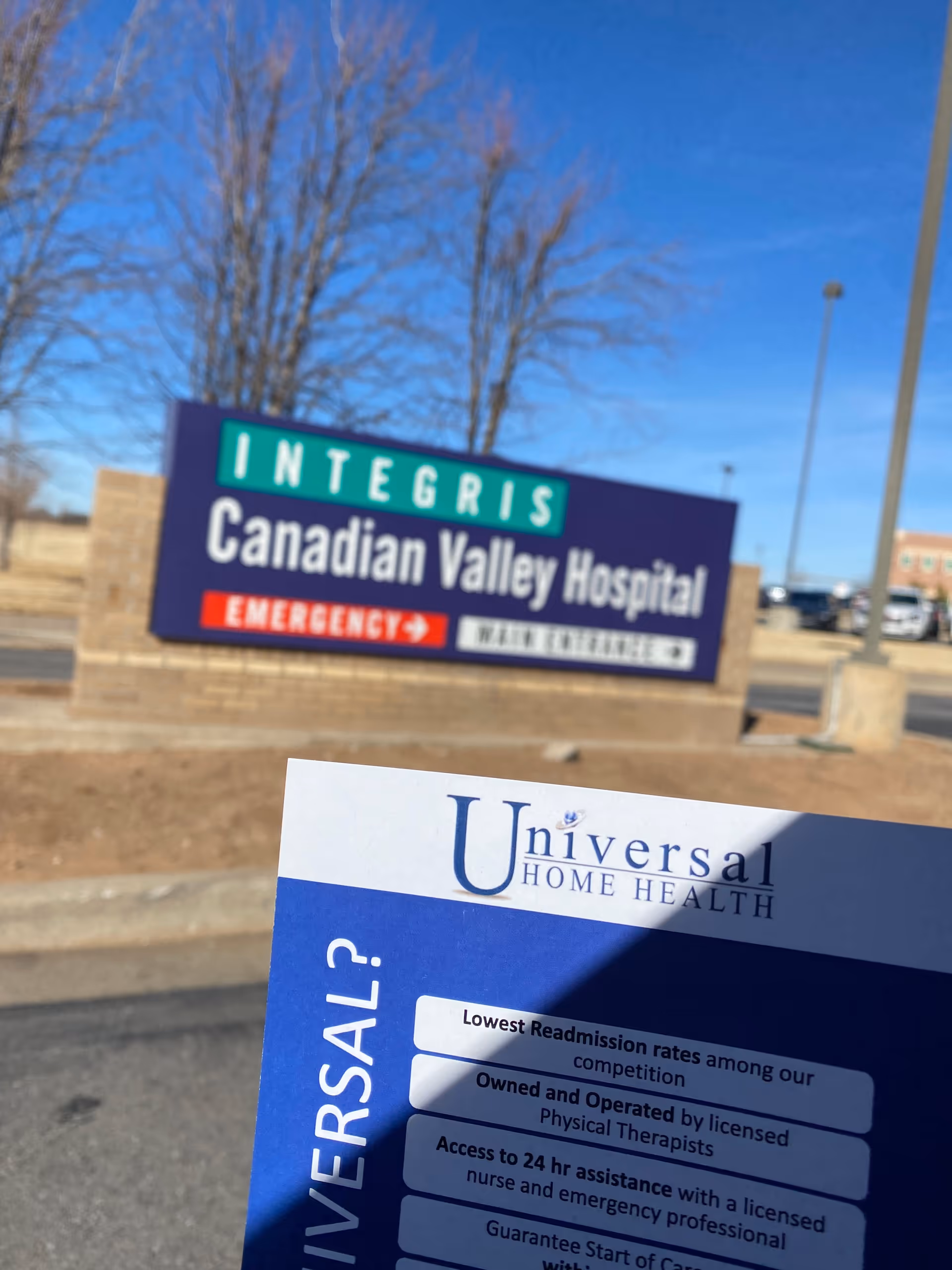 Foreground Universal Home Health brochure; background displays Canadian Valley Hospital exterior sign in a parking lot.