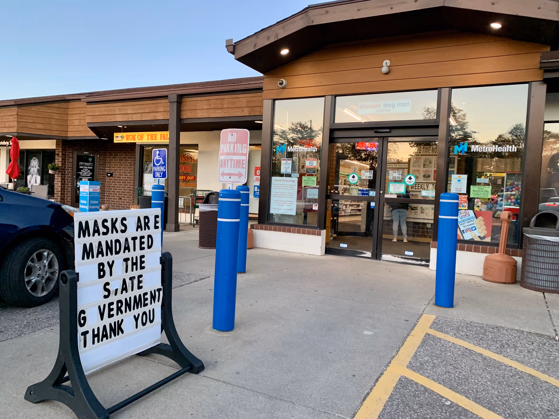Exterior view of Discount Drug Mart storefront with glass doors and a parking lot.