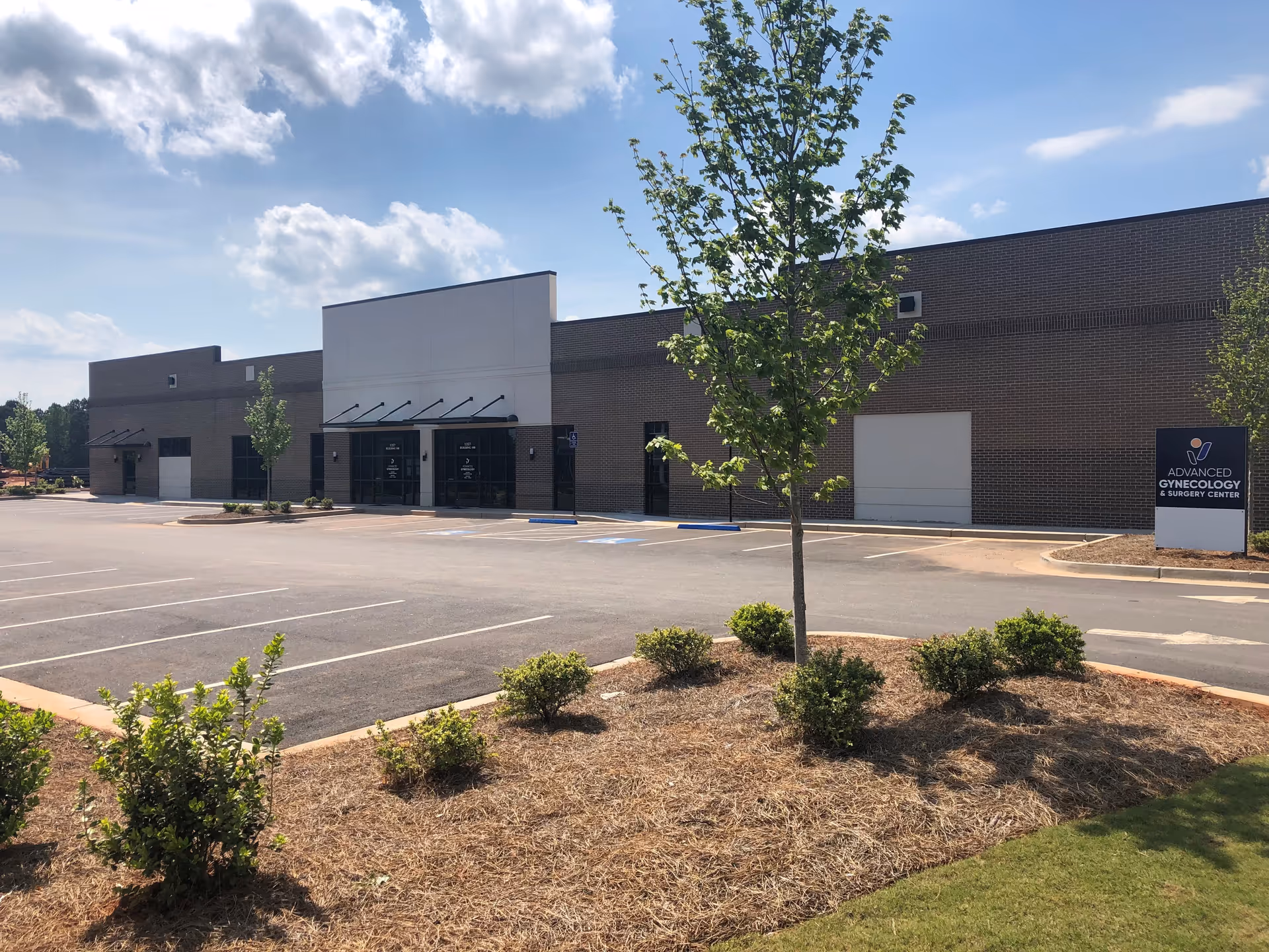Exterior view of Advanced Gynecology building with parking lot and landscaping.