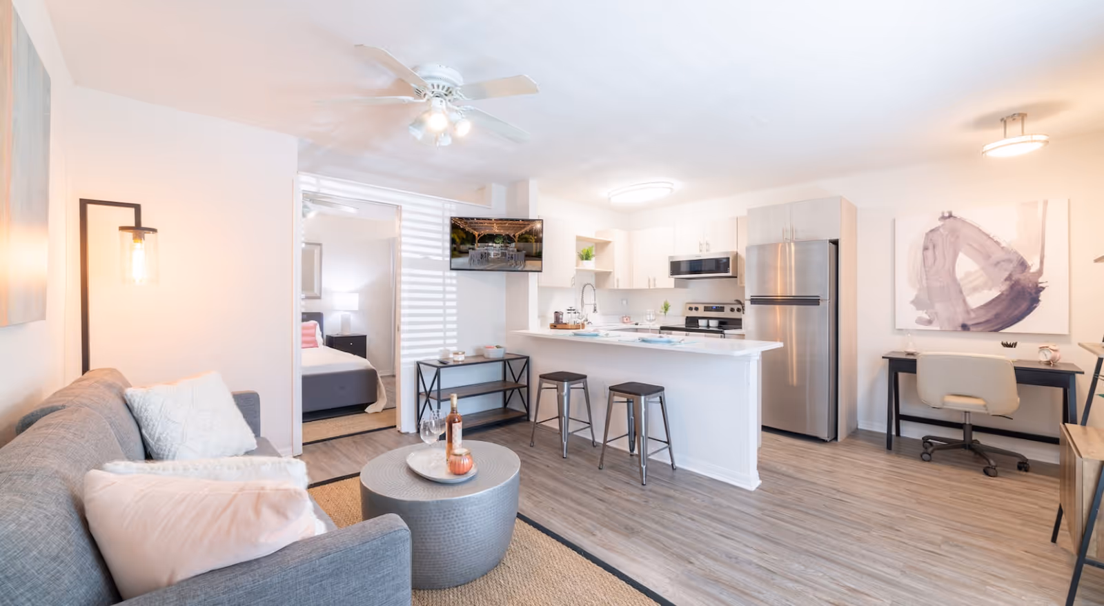 Open-concept living area with sofa, kitchen island, and stainless-steel appliances.