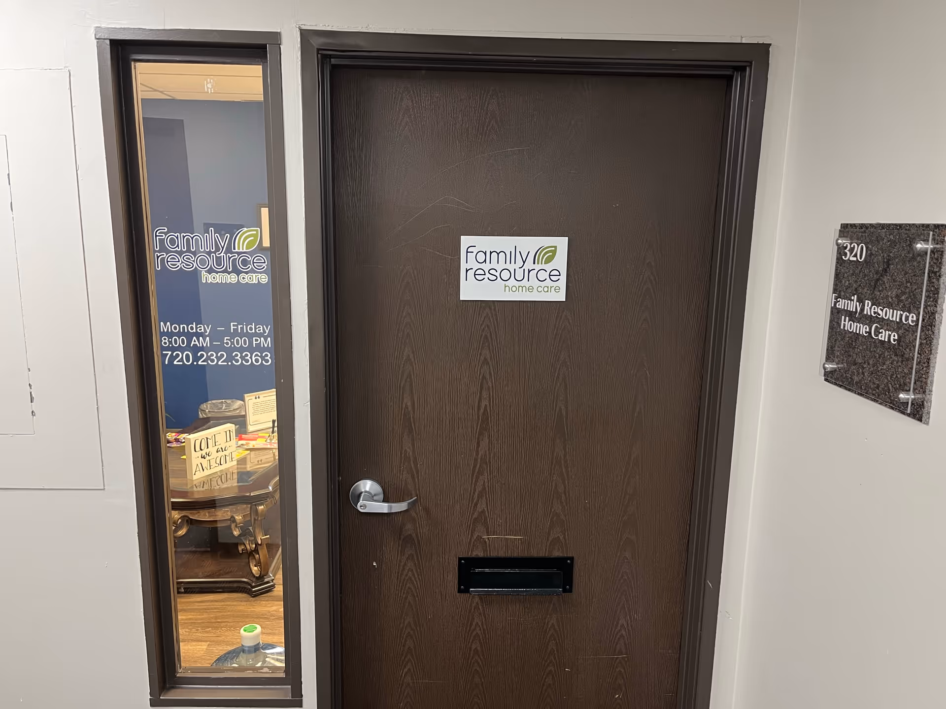 Indoor hallway with a brown door labeled Family Resource Home Care and a windowed wall panel