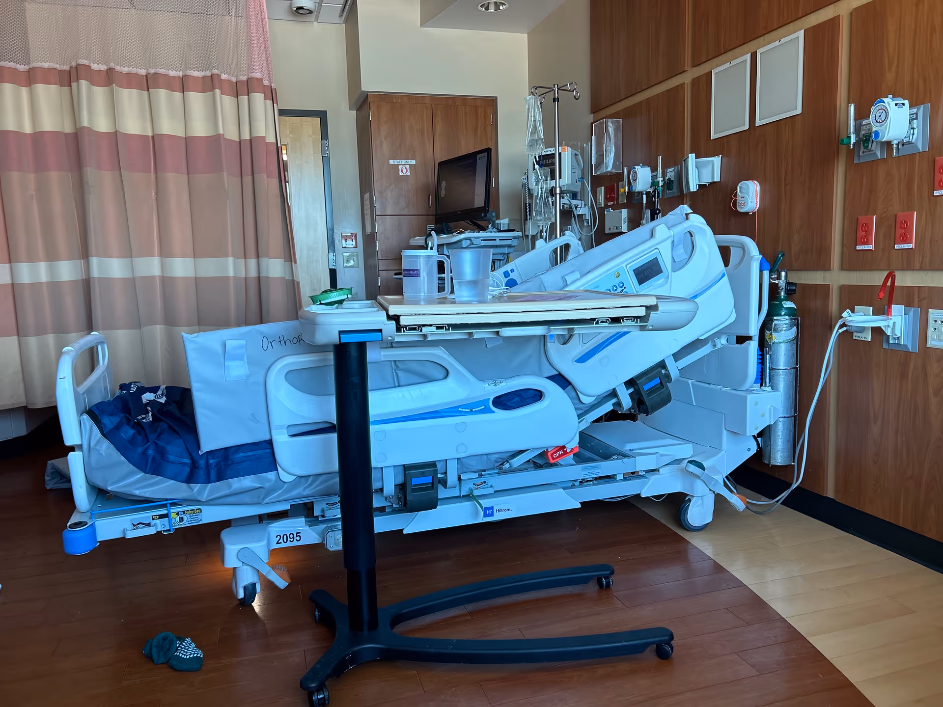 A hospital bed equipped with monitors and IV poles in a patient room.