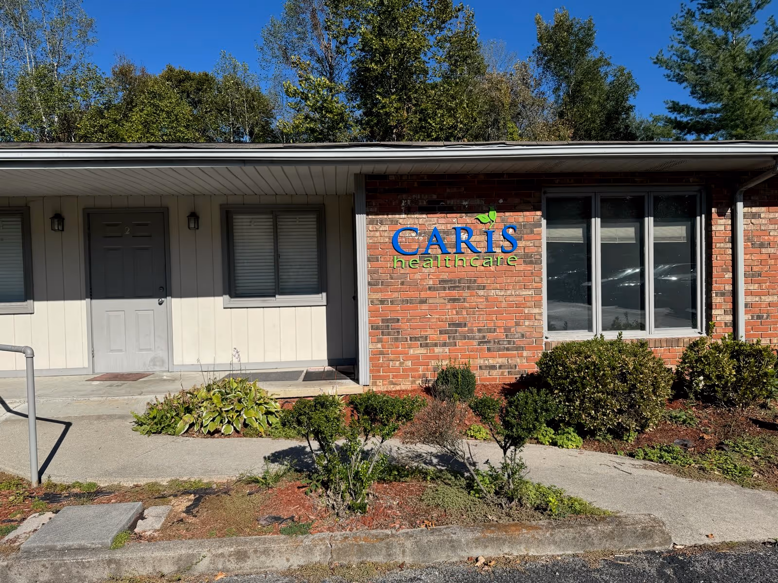 Caris Healthcare building front with brick exterior and landscaped entry.