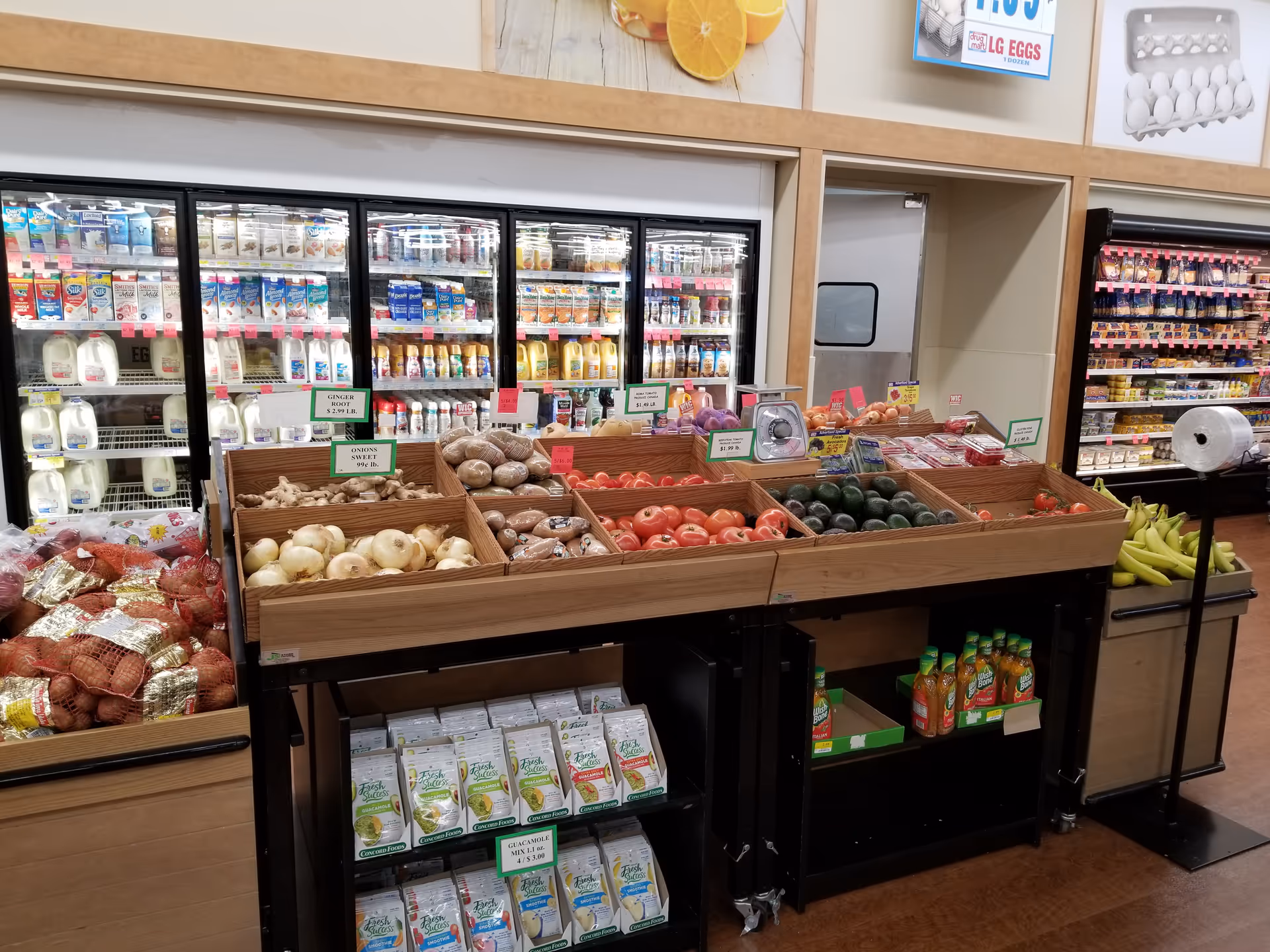 Interior of a senior living facility grocery area with produce bins and refrigerated shelves.