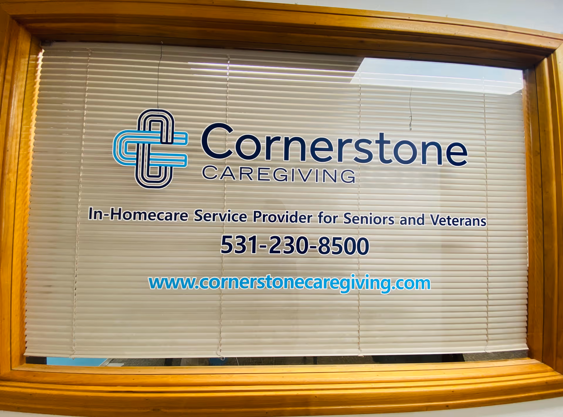 Cornerstone Caregiving logo and contact information displayed in a window with blinds