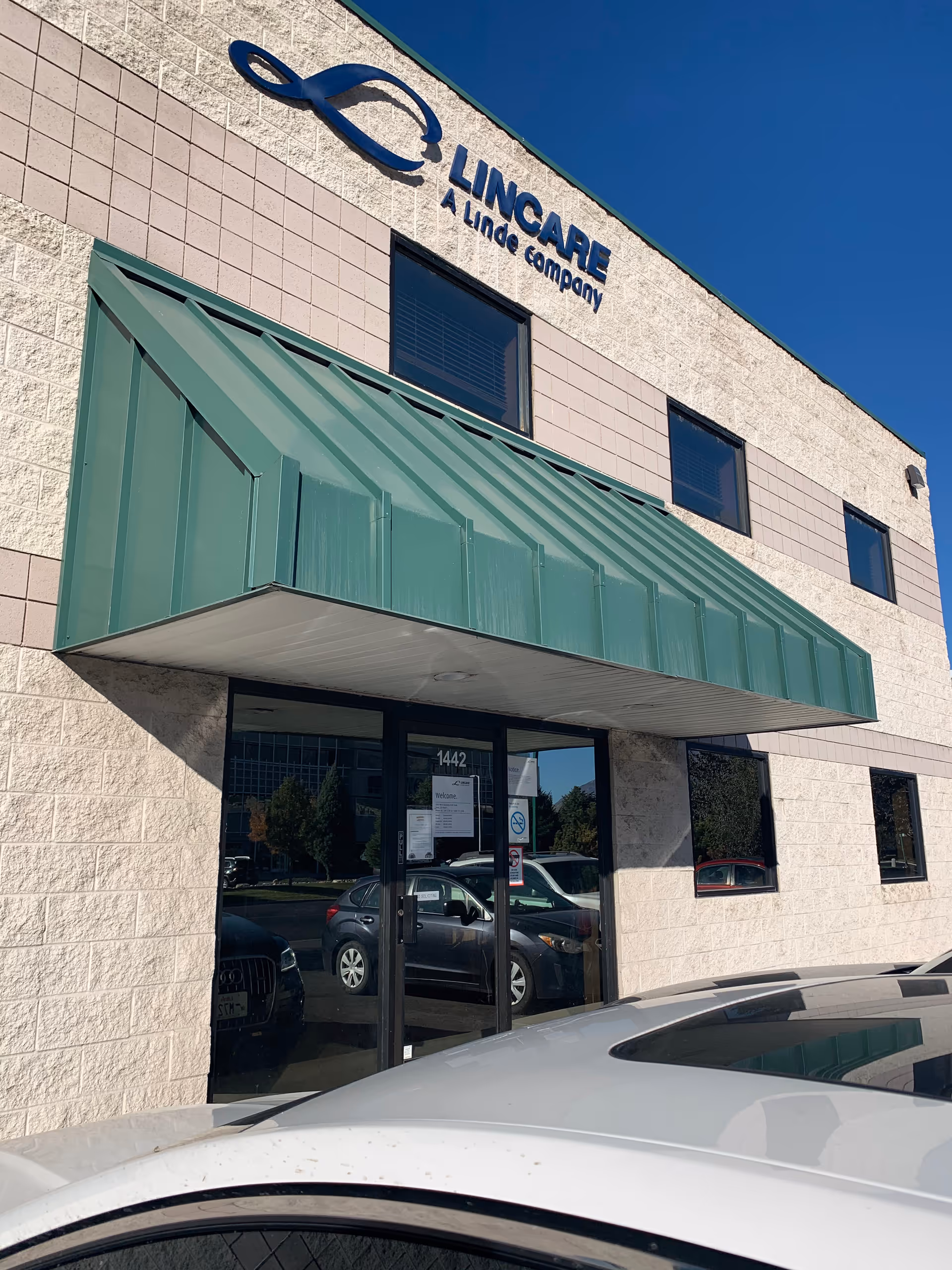 Exterior view of LINCARE facility with green awning and glass entry doors.