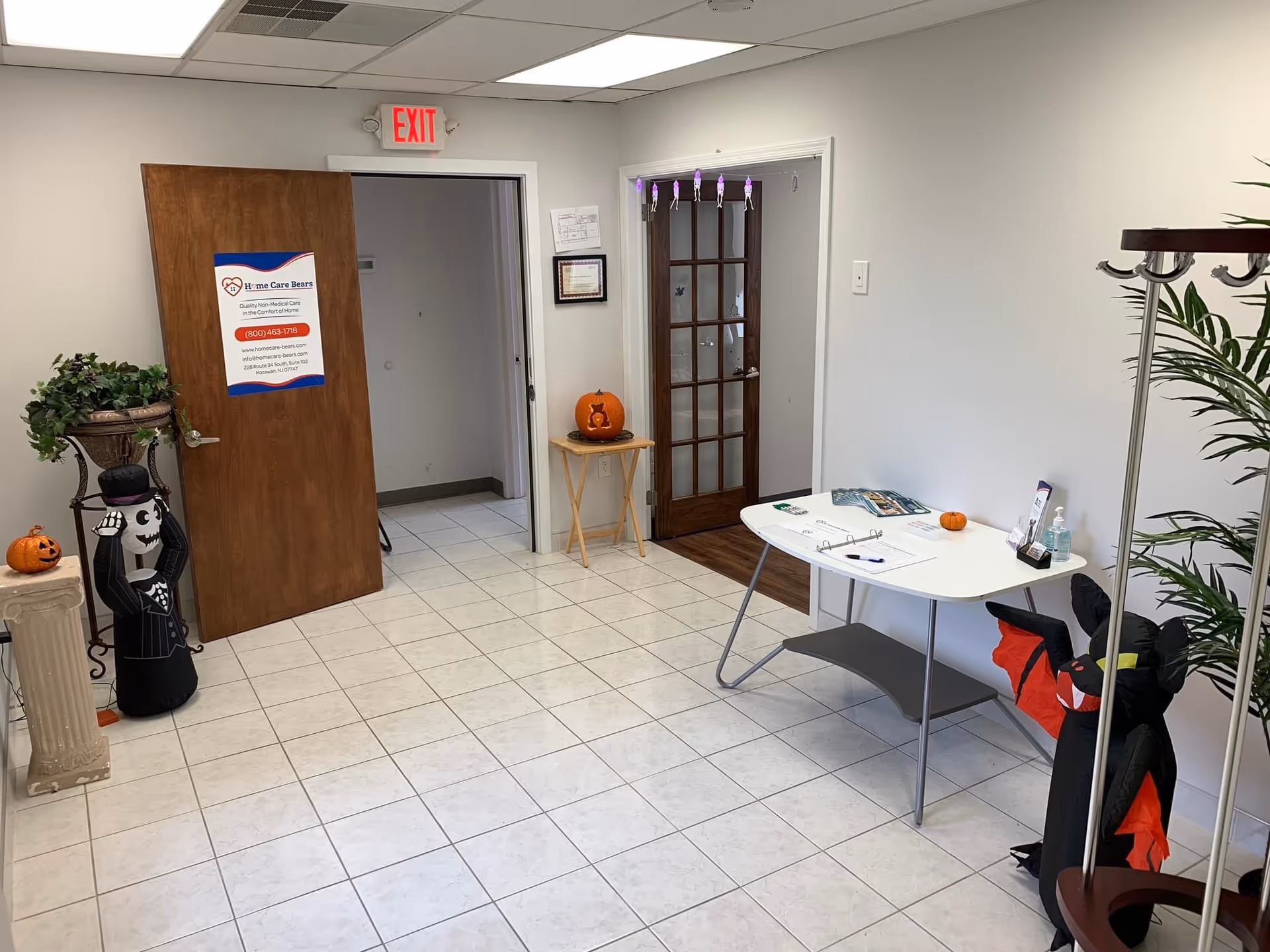 Interior lobby of Home Care Bears facility with pumpkins, Halloween decor, a desk, and plants.