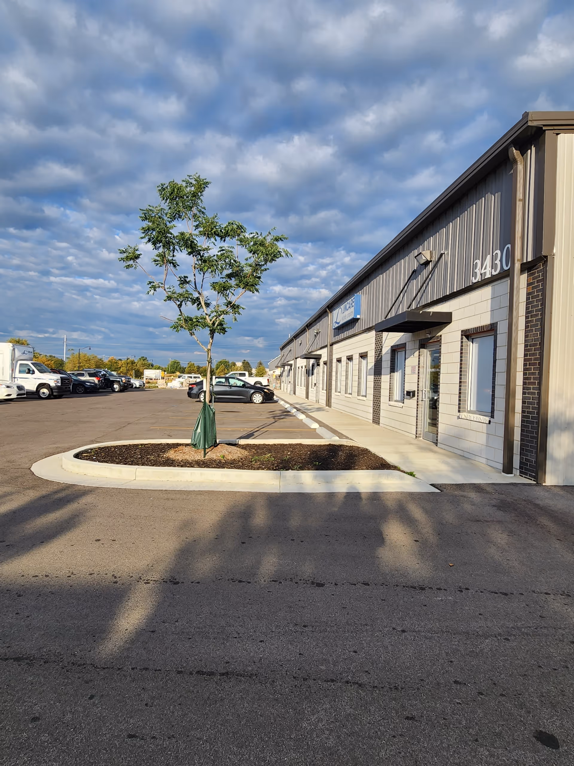 Exterior view of LINCARE facility with a tree-lined landscape and parking lot.