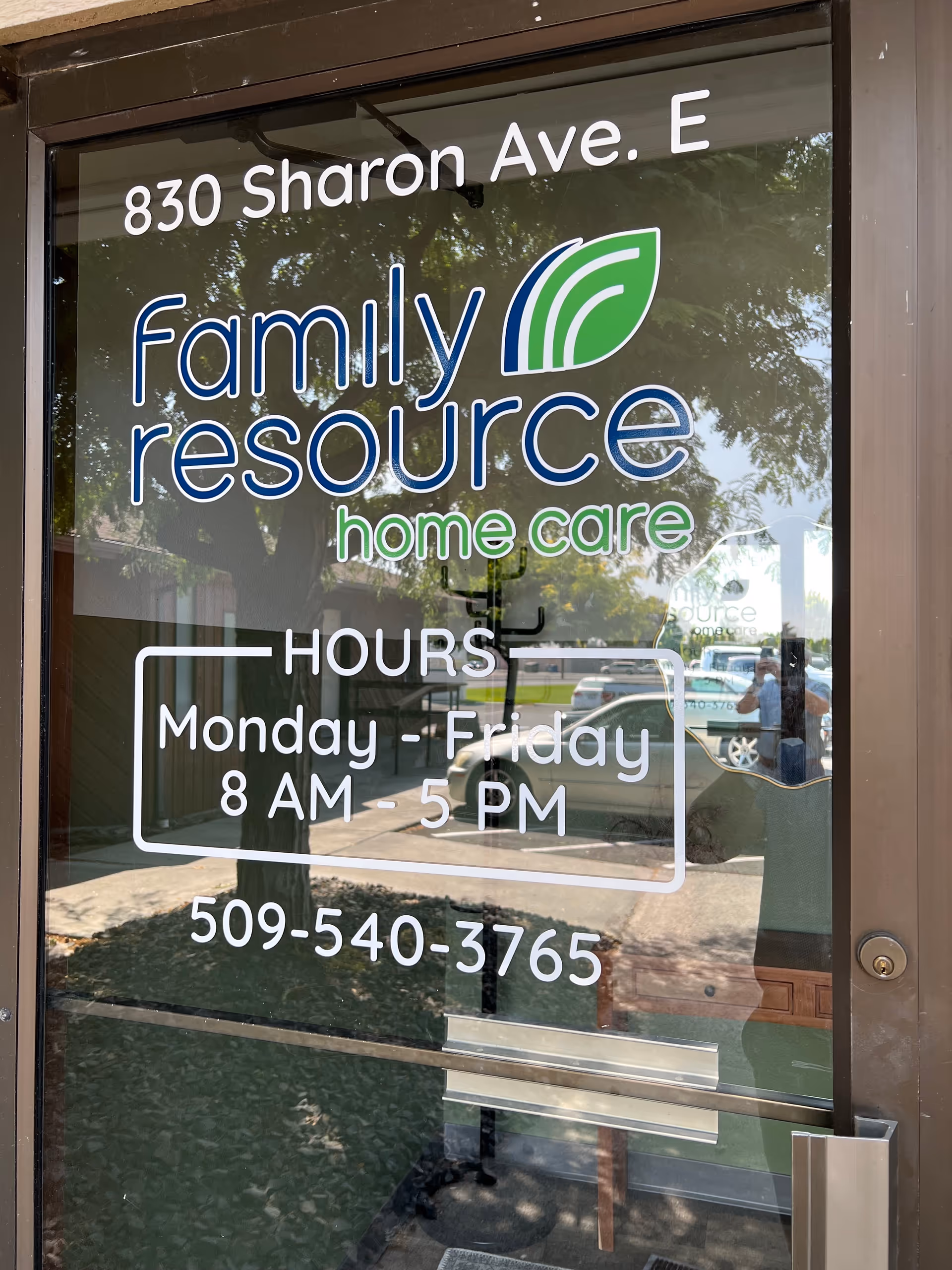 Storefront glass door displaying Family Resource Home Care sign and hours.