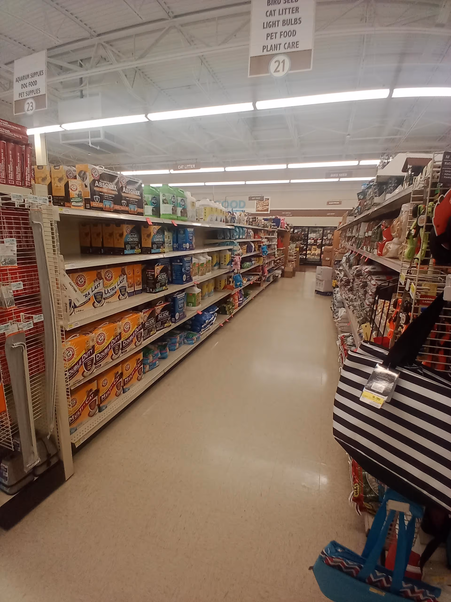 Interior of a discount drugstore aisle with tall shelves stocked with household supplies.