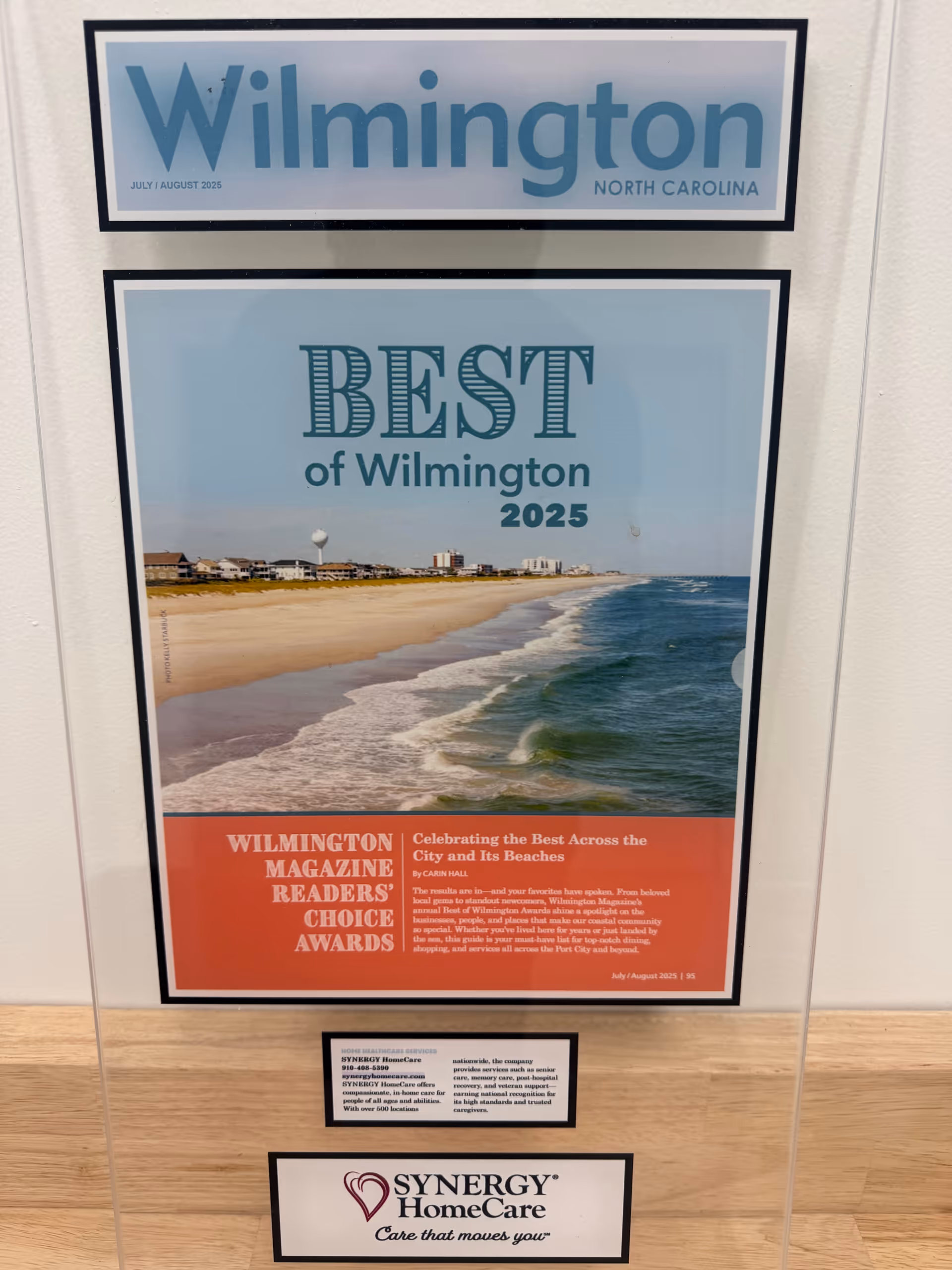 Interior wall frame displaying Best of Wilmington 2025 award poster and Synergy HomeCare logo.