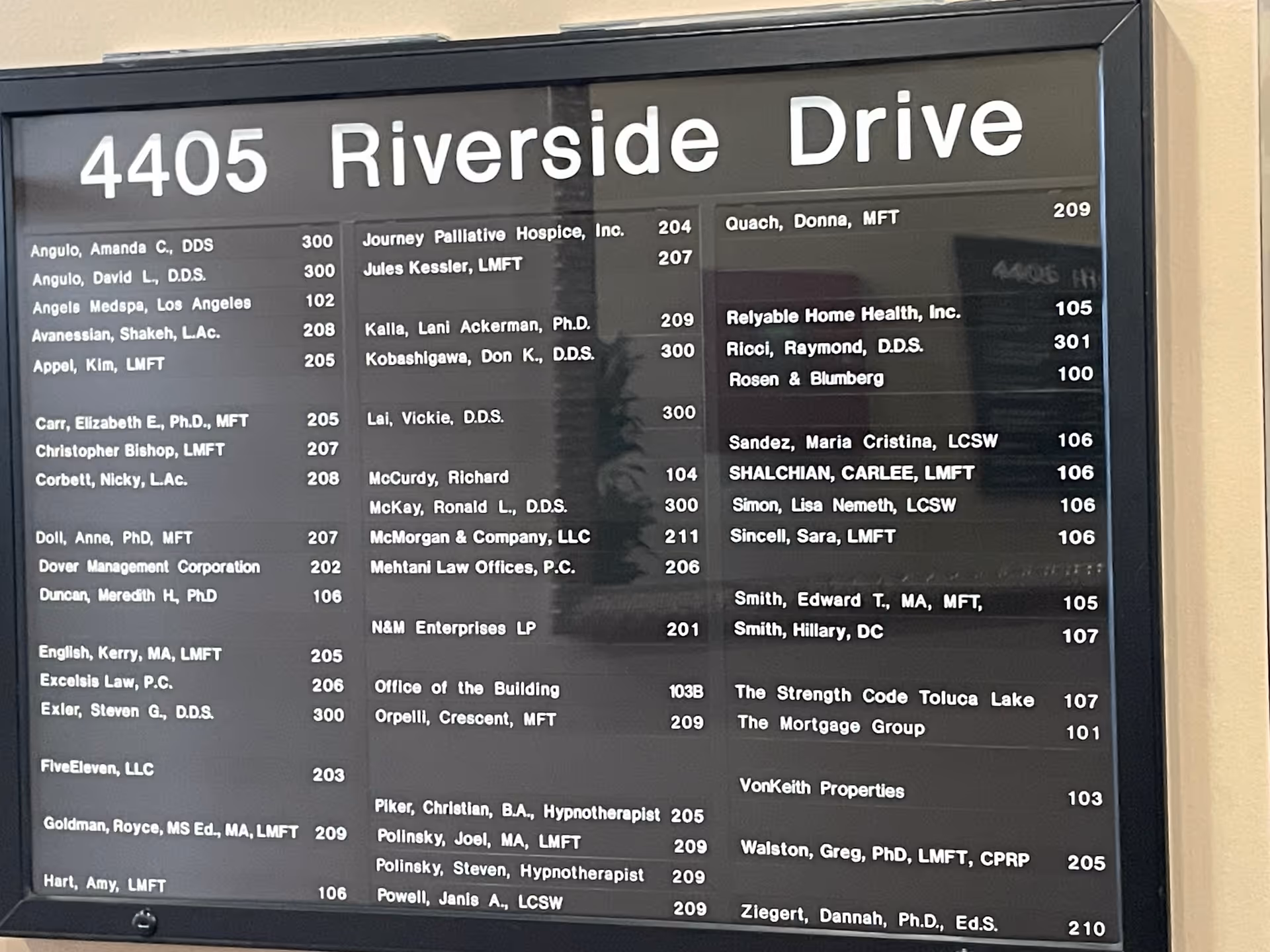 Large black building directory board listing tenant names and suite numbers.