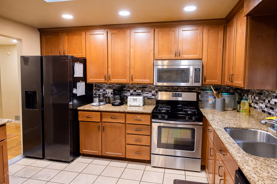 Kitchen with wooden cabinets, granite countertops, and stainless steel appliances in a homey setting.