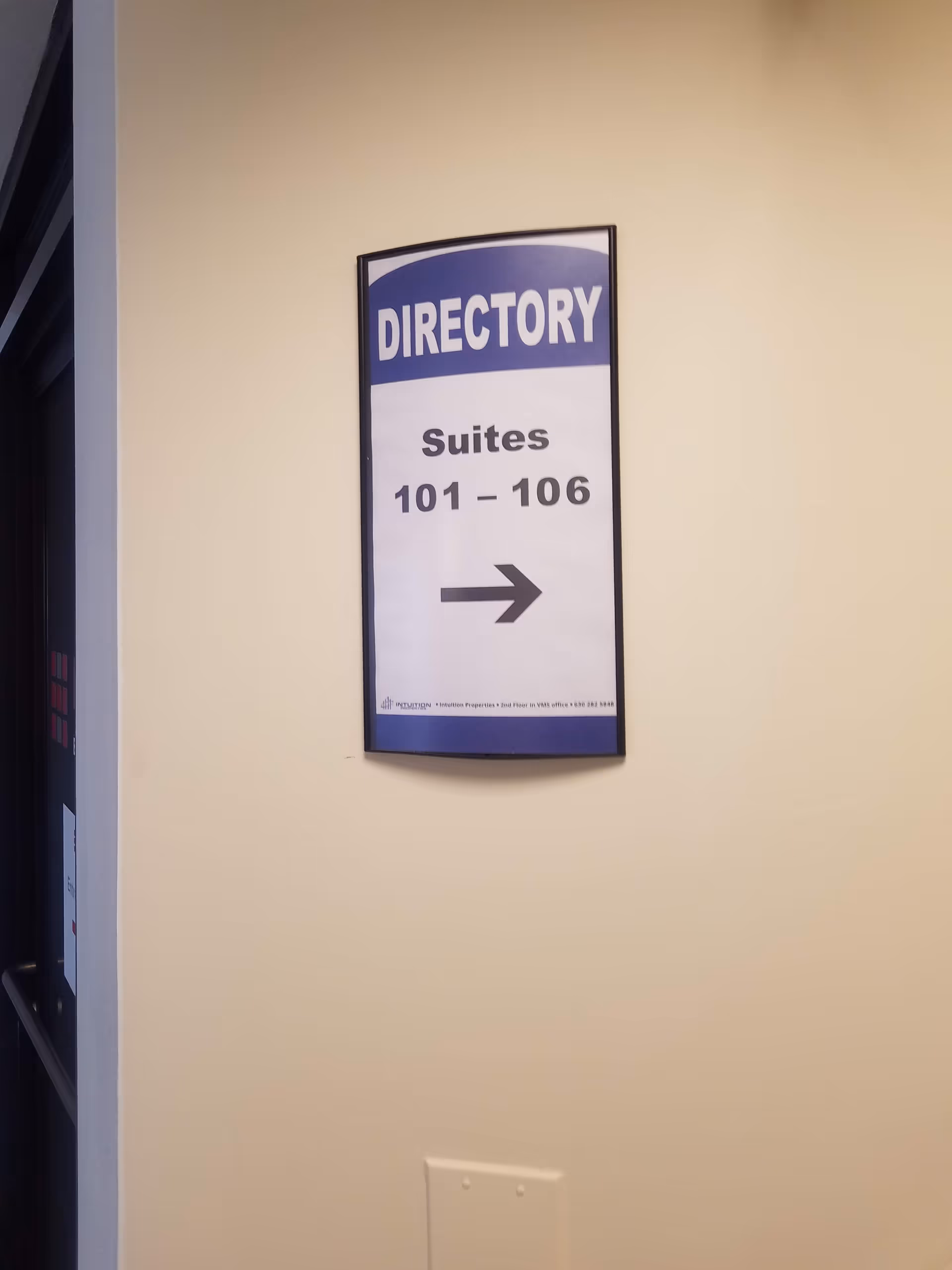 Interior wall-mounted directory sign reading Suites 101-106 with an arrow