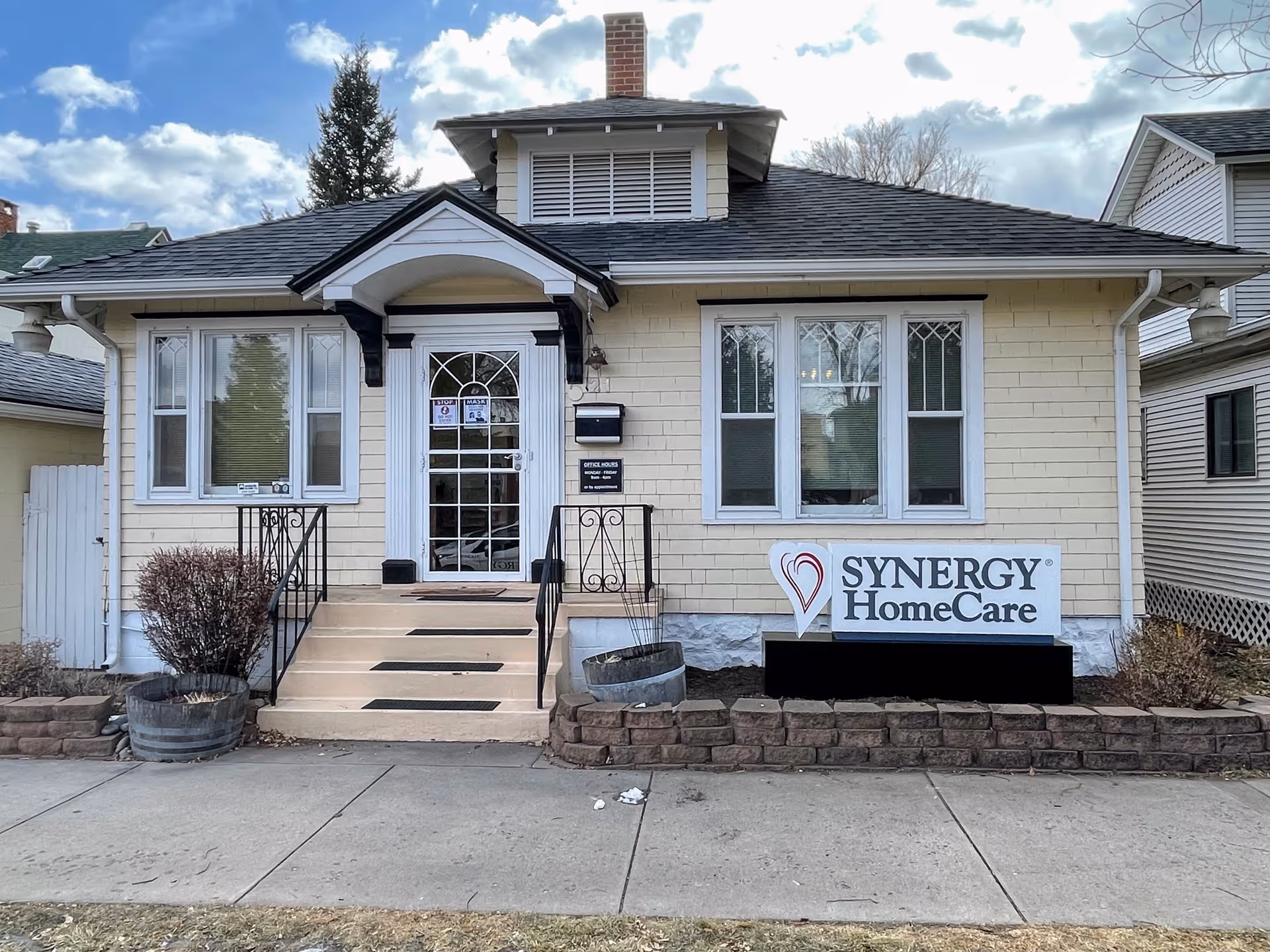 Front view of SYNERGY HomeCare building with steps, sign, and large windows.