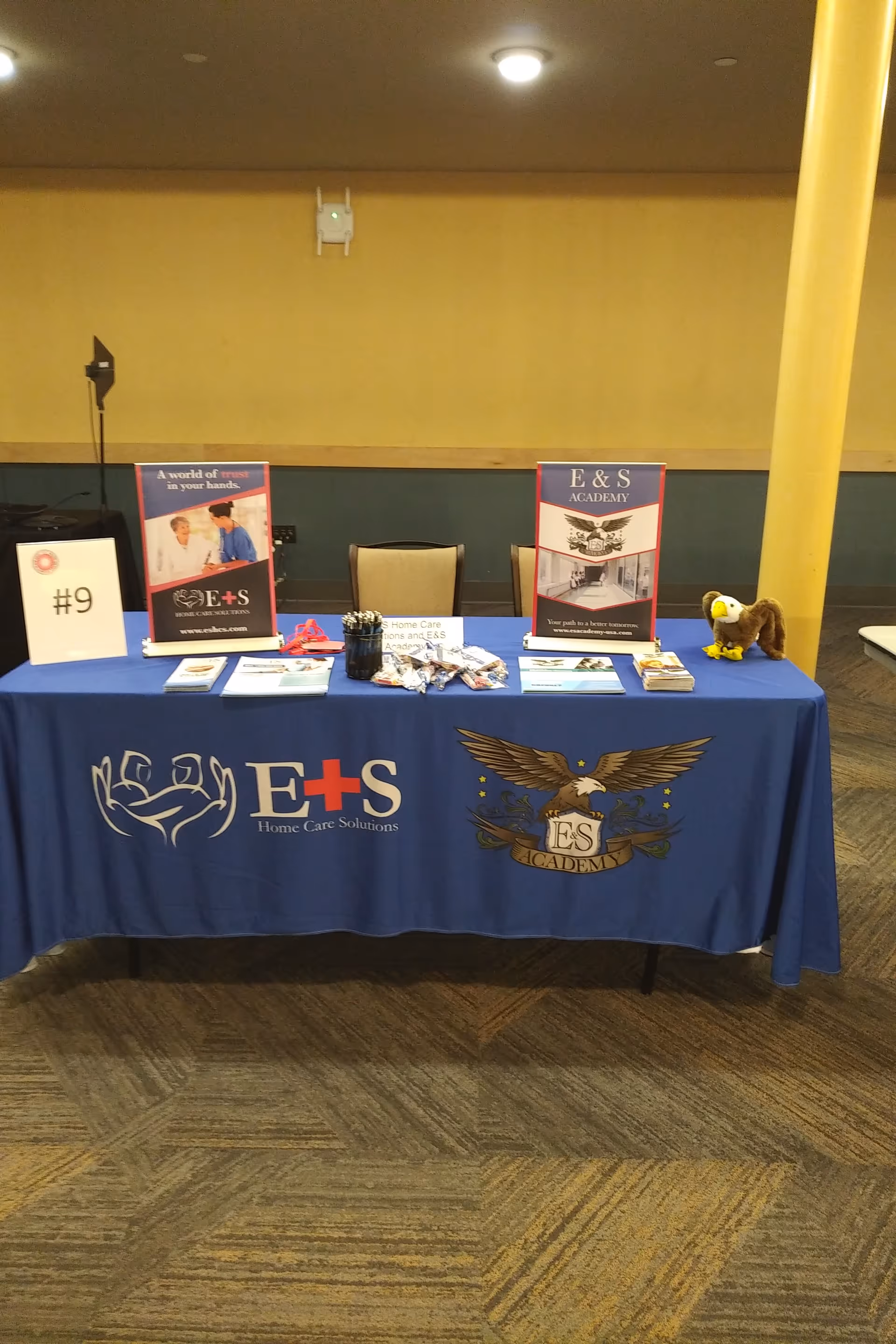 Indoor display table for E&S Home Care Solutions with brochures and banners.