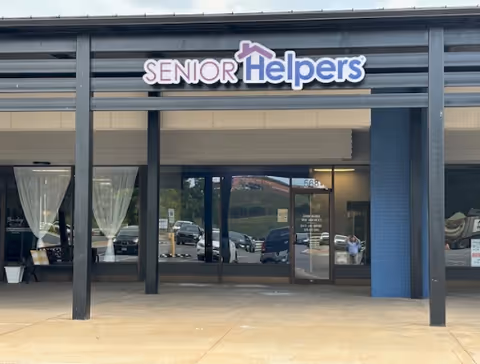 Facade of Senior Helpers facility with glass doors and sign above entrance.