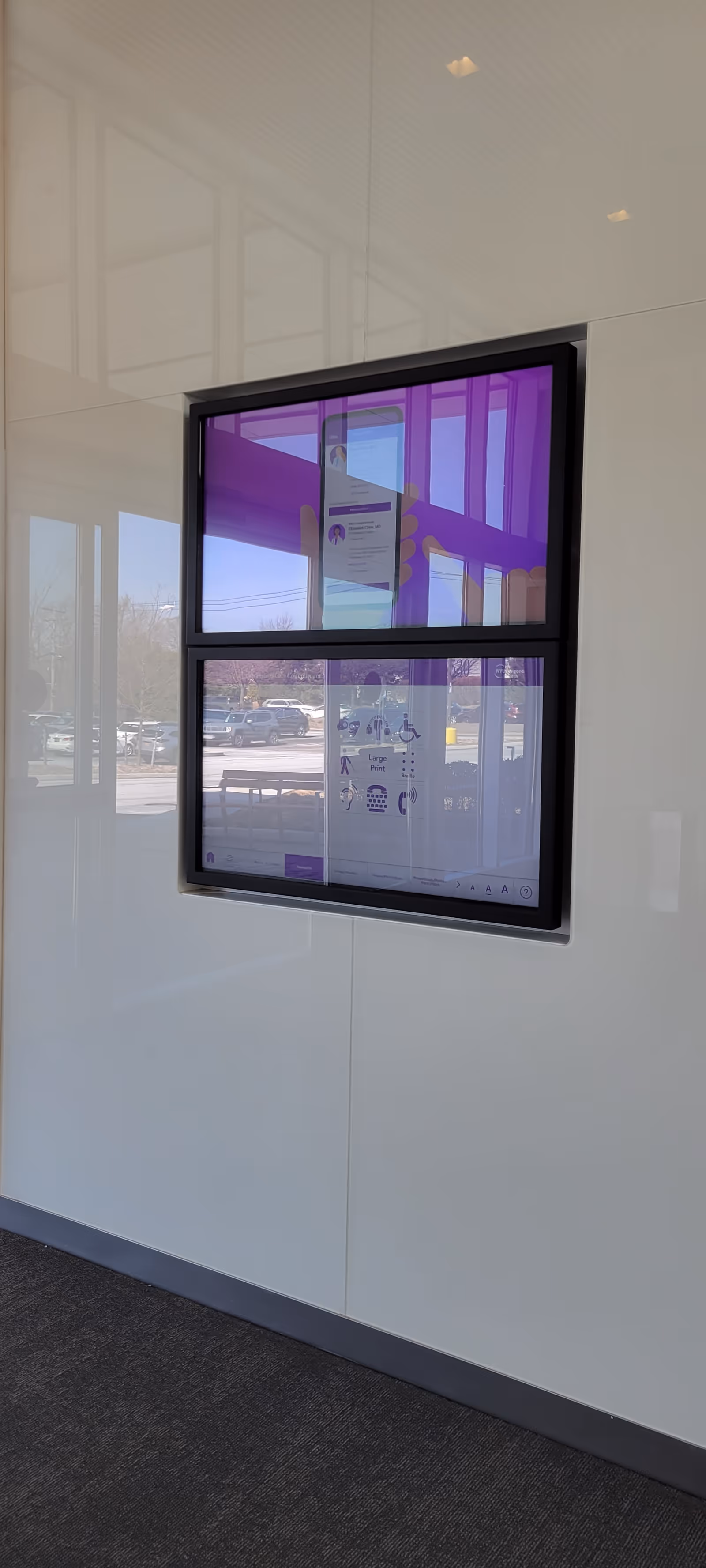 Interior wall with a mounted purple-tinted information display panel.