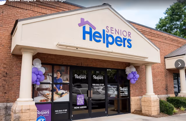 Exterior view of a Senior Helpers facility with purple logo above entrance.