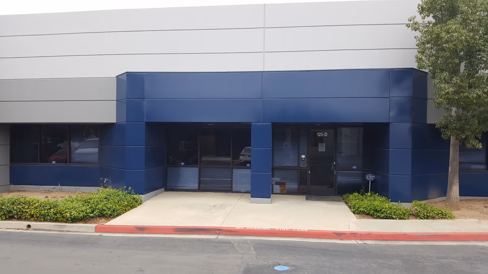 Exterior view of a blue-accented building entrance with glass doors.