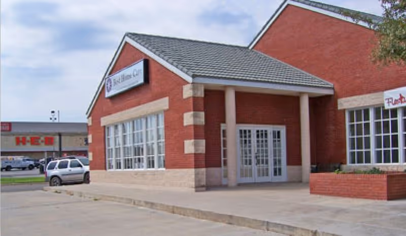 Red brick building entry with double doors and Enhabit Home Health signage.