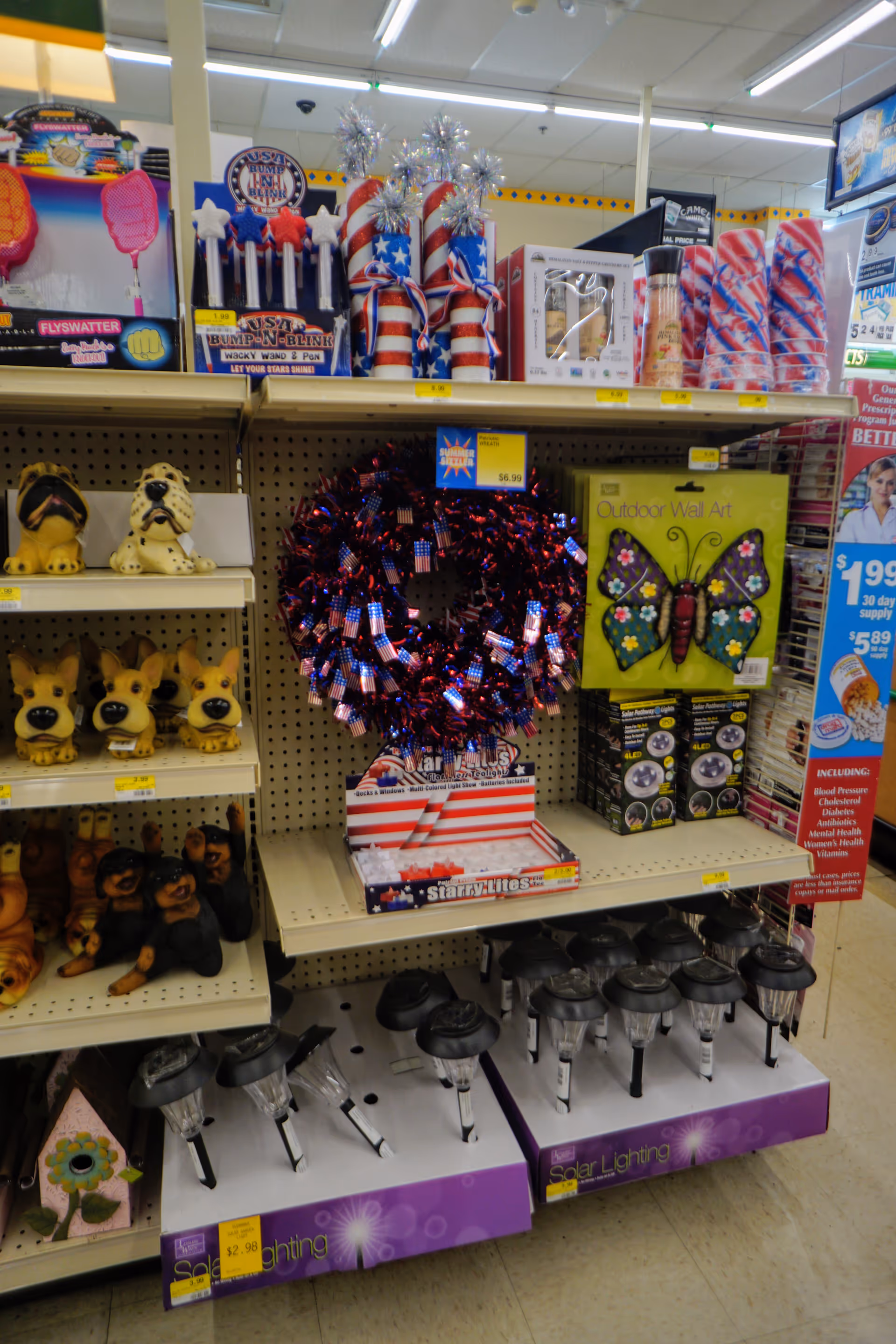 Interior store aisle with assorted decorations, toys, and lighting fixtures on metal shelves.